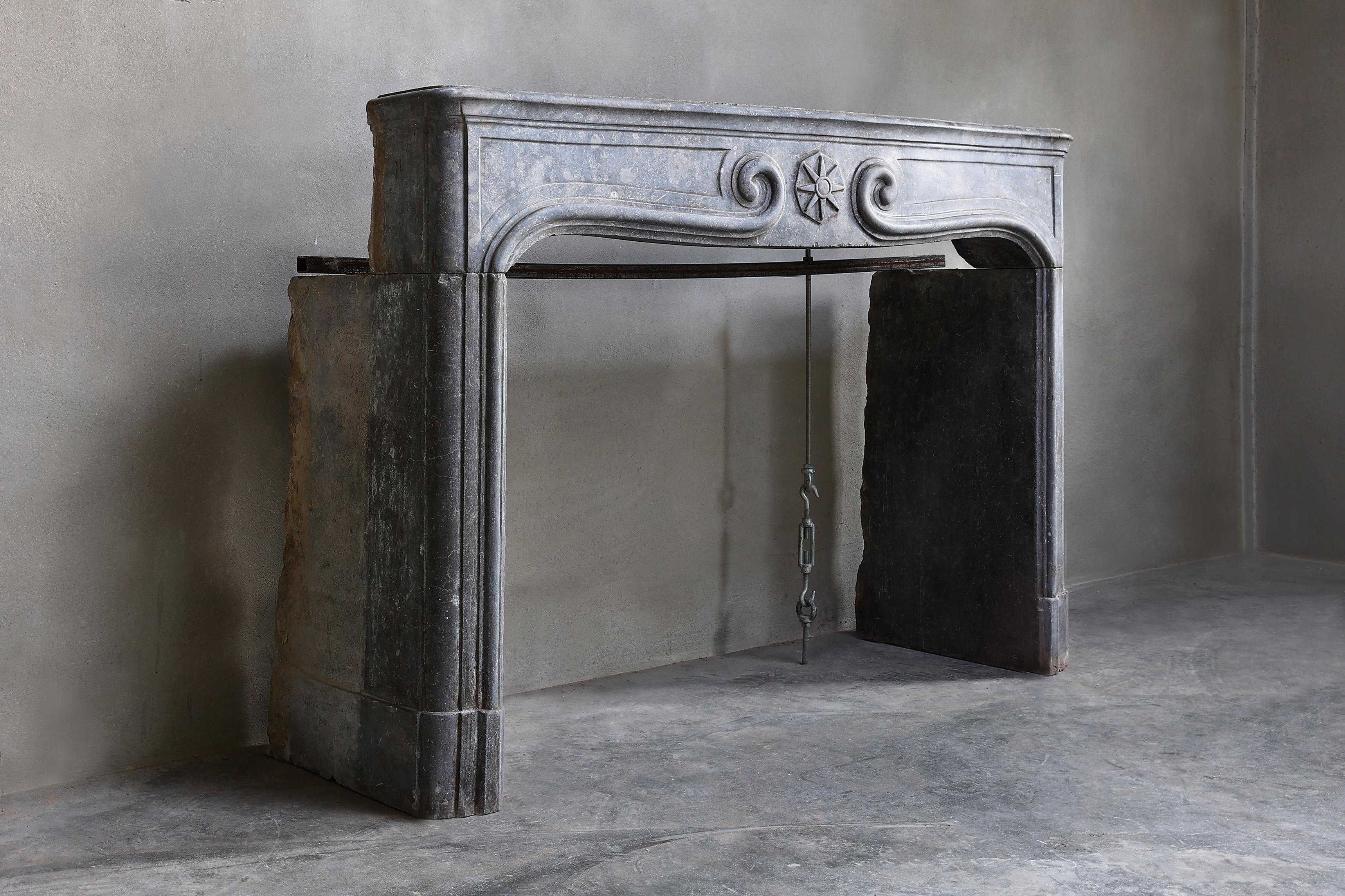 Beautiful antique fireplace in a gray color scheme. This model fireplace is in the style of Louis XIV and is made of marble stone. We got this fireplace from France from the Dordogne region. A fireplace with beautiful lines and more diverse ornate