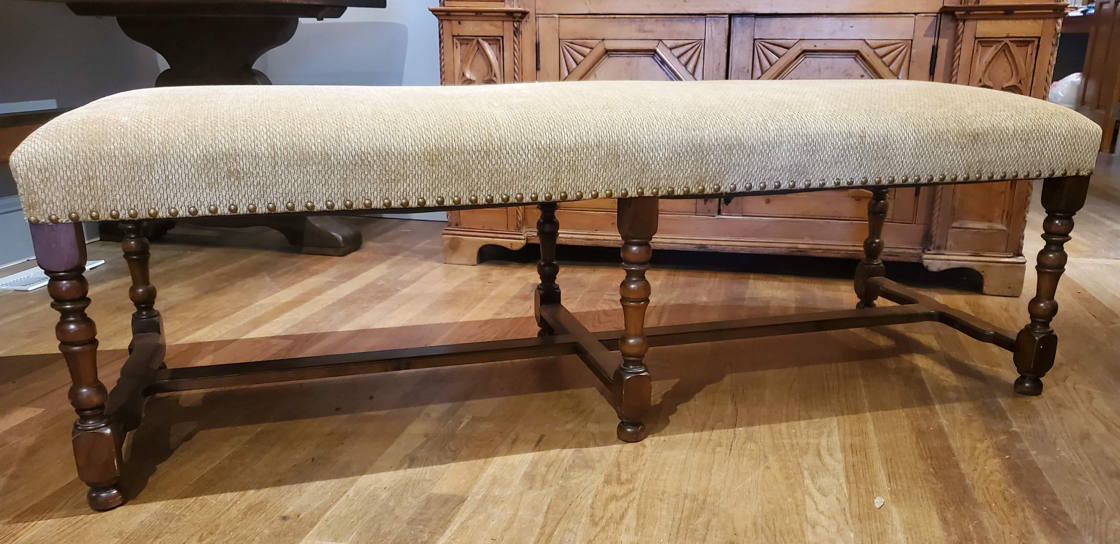 This lovely Louis XIV style French Provincial upholstered bench is the perfect for the foot of your bed or a comfy addition to your large dining room table. Made of walnut with six turned legs and stretchers and upholstered in a tan textured