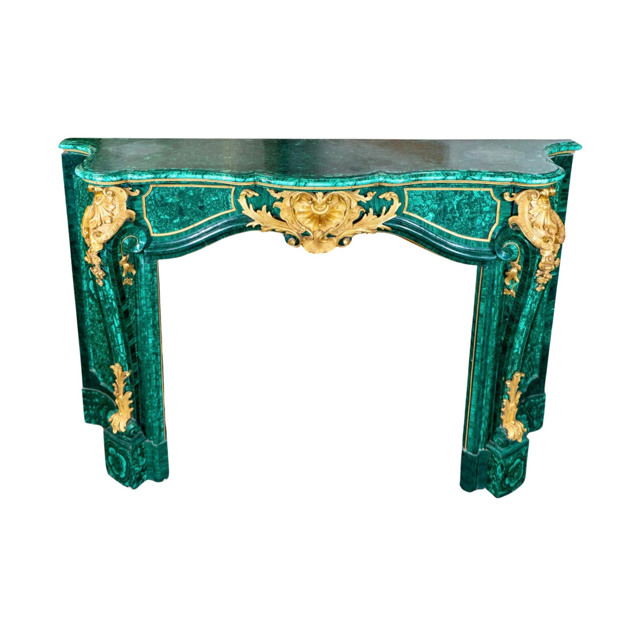 This French Marble Mantel from the 20th century is a luxurious addition to any home. Crafted in the elegant Louis XIV style, it features stunning malachite stone in a beautiful emerald green color. The gilded bronze accent mounts add a touch of