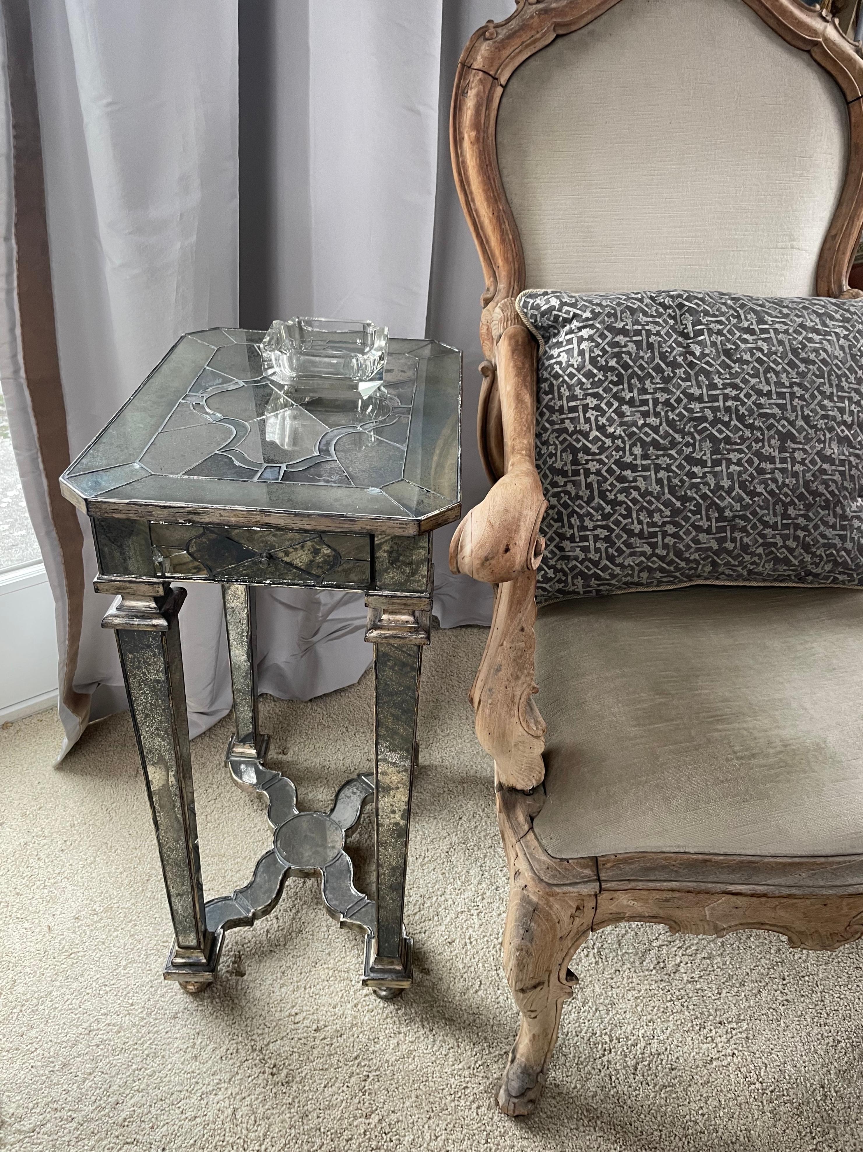 Louis XIV style mercury glass side table. Vintage Venetian style silvered wood and mercury glass covered night stand side table with small drawer below shaped top with inlaid design antiqued mercury glass top supported on four tapered mirrored legs