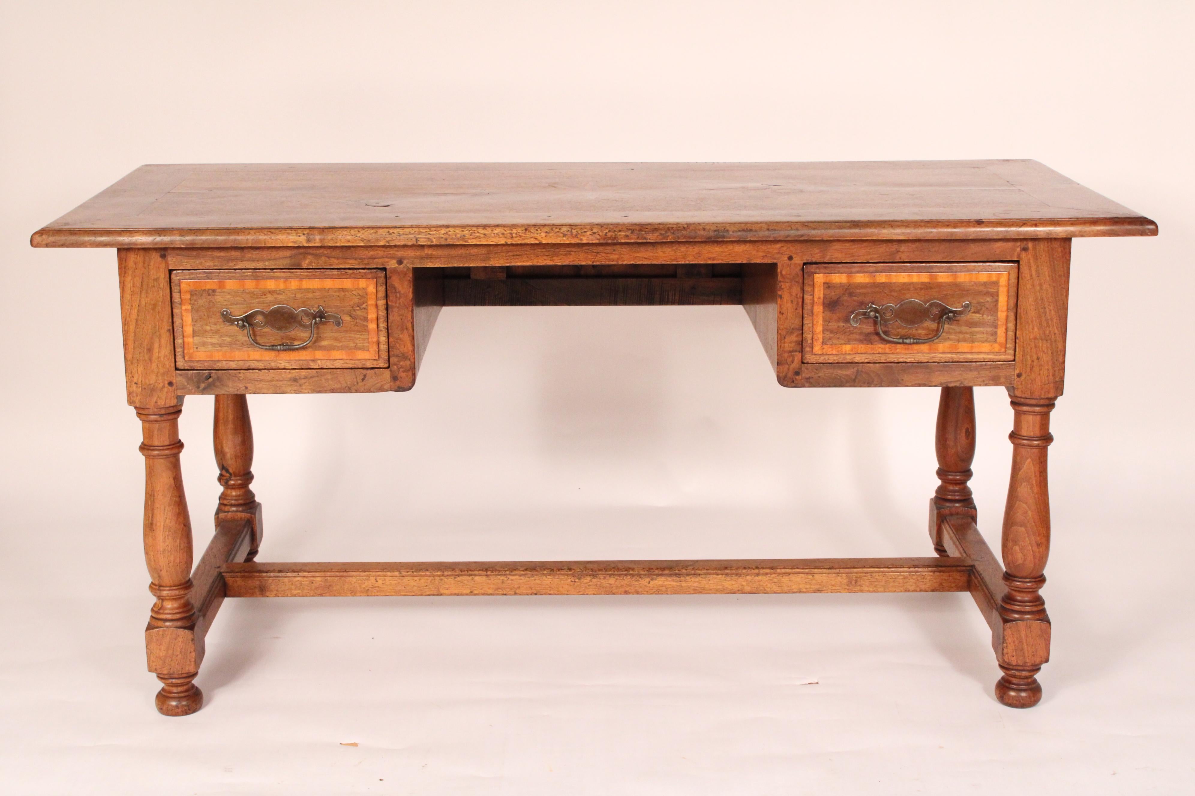 Scrivania in noce in stile Luigi XIV, realizzata con elementi antichi e successivi, assemblata negli anni '50 circa. Con un piano rettangolare con bordi a fasce larghe 5