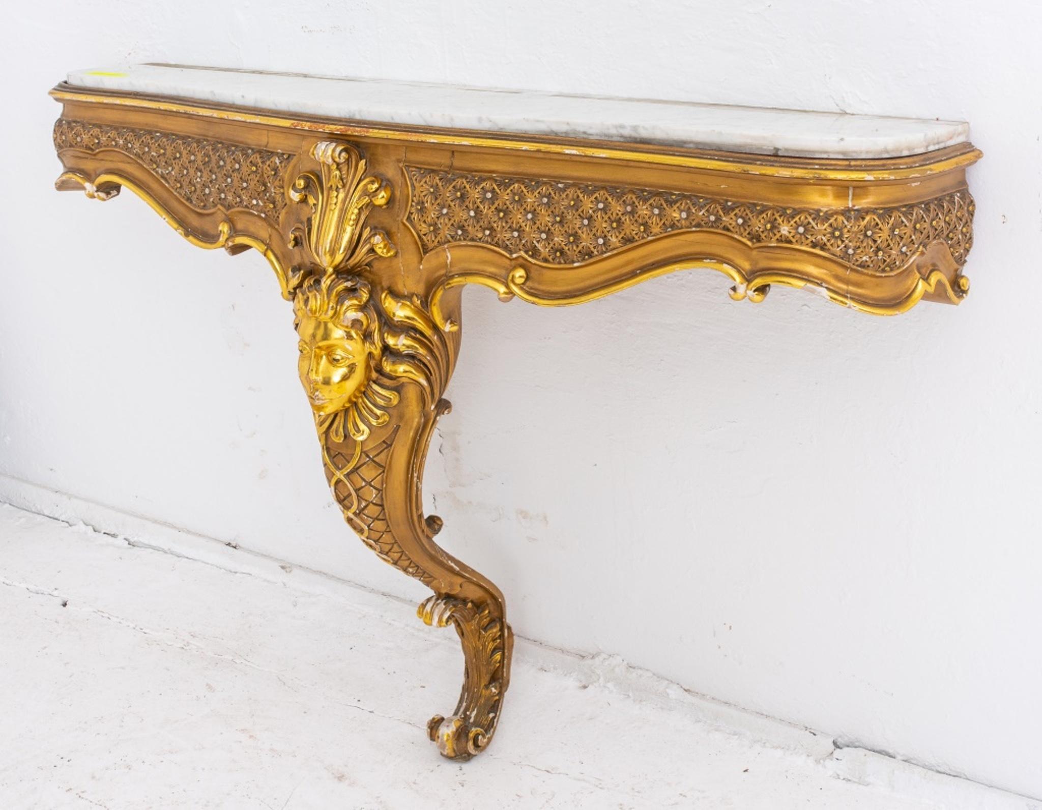 Louis XIV fantasy style monopodal console, the shaped rectangular top above a molded frame, the sides and fronts with a rosette diapered pattern, centering a floral crowned masque above a scrolling foliate volute leg. In very good vintage condition.
