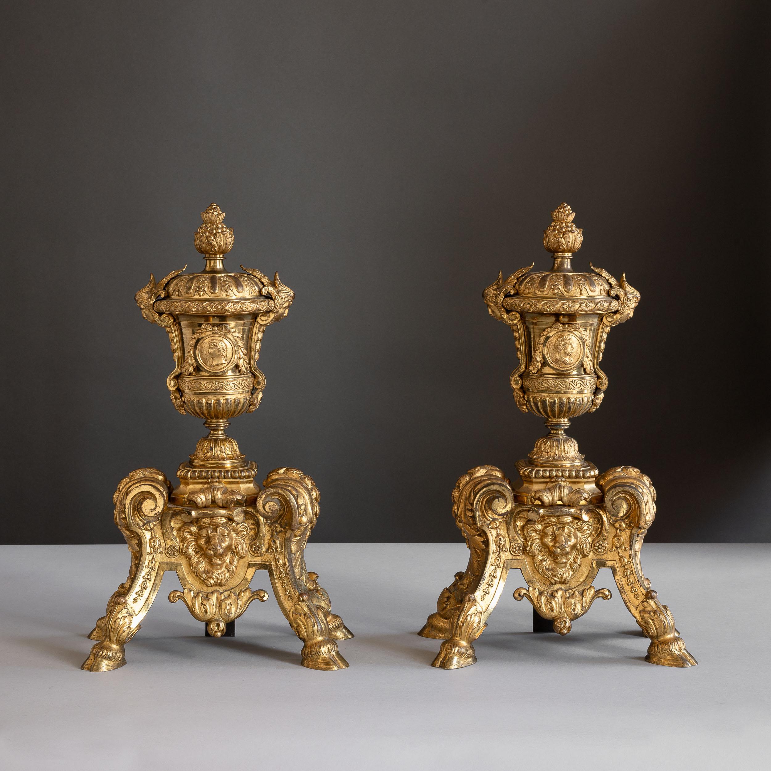 A pair of French nineteenth century gilt-bronze chenets, in the Louis XIV style,
the flaming urn finials with inset medallions depicting Hadrian and Trajan.

For further reading relating to these and similar chenets see ‘Nouveaux dessins de meubles