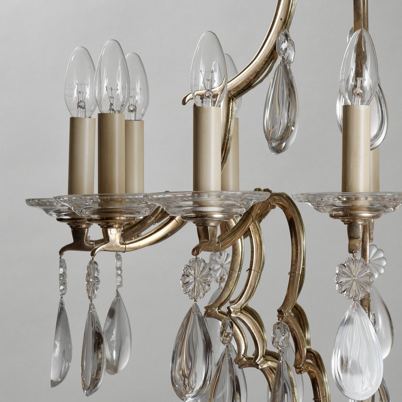 Louis XIV Style Silvered Bronze and Crystal Chandelier by Gherardo Degli Albizzi: birdcage chandelier in silvered bronze with rosettes and big crystal drops.
This chandelier features twelve lights and each arms has spurs from which crystals hang.