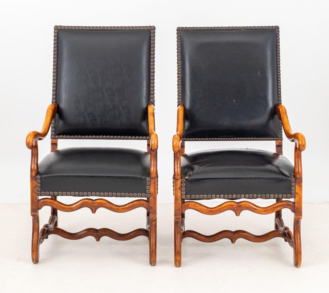 Pair of Louis XIV Style Walnut Fauteuil, with riveted black leather upholstery on four carved wood legs conjoined by H-form stretcher. 44