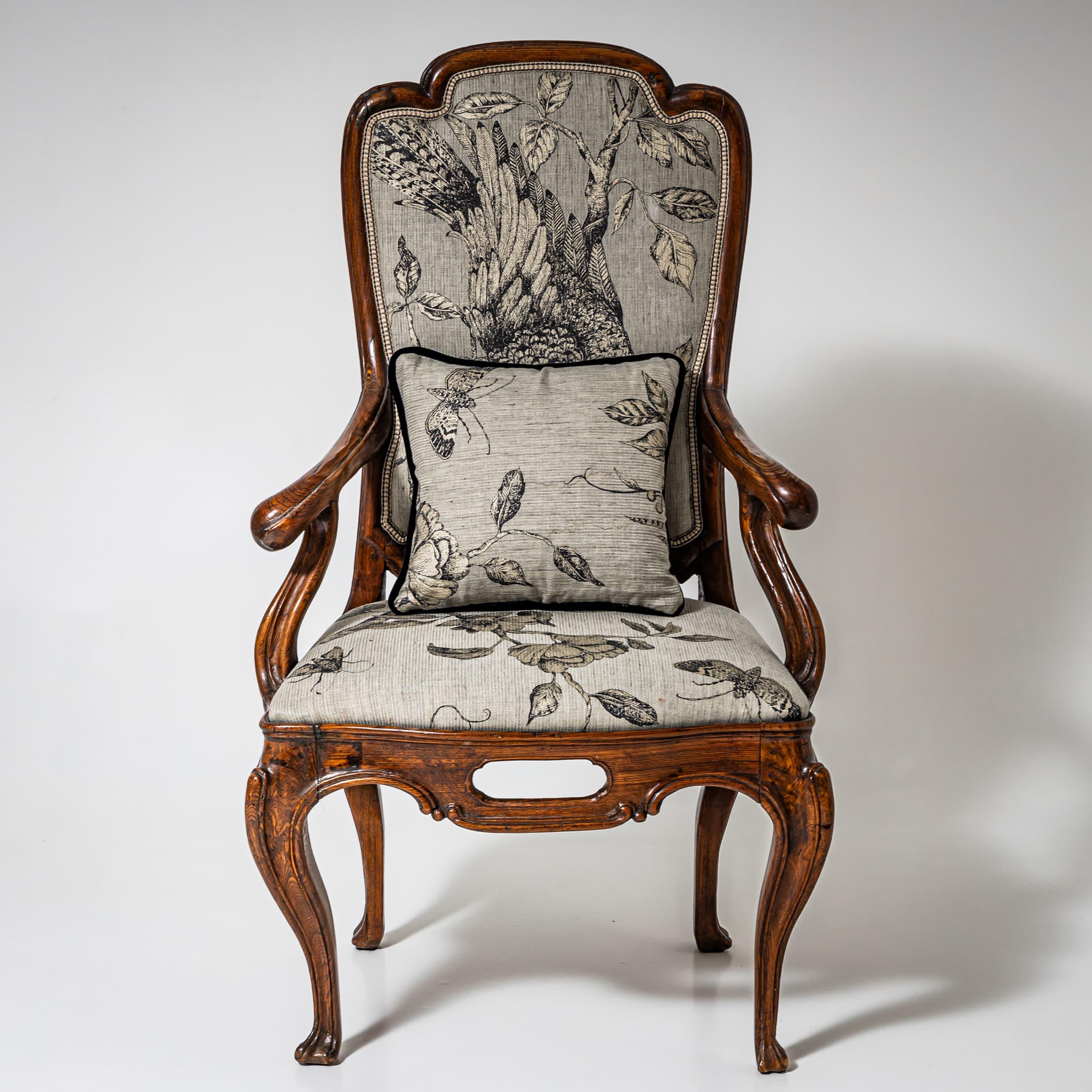 Impressive Louis XV armchair crafted from solid walnut with a generously proportioned frame. Standing on elegant cabriole legs, it features a finely carved, pierced serpentine apron. The outward-curving armrests flow gracefully into the tall, shaped
