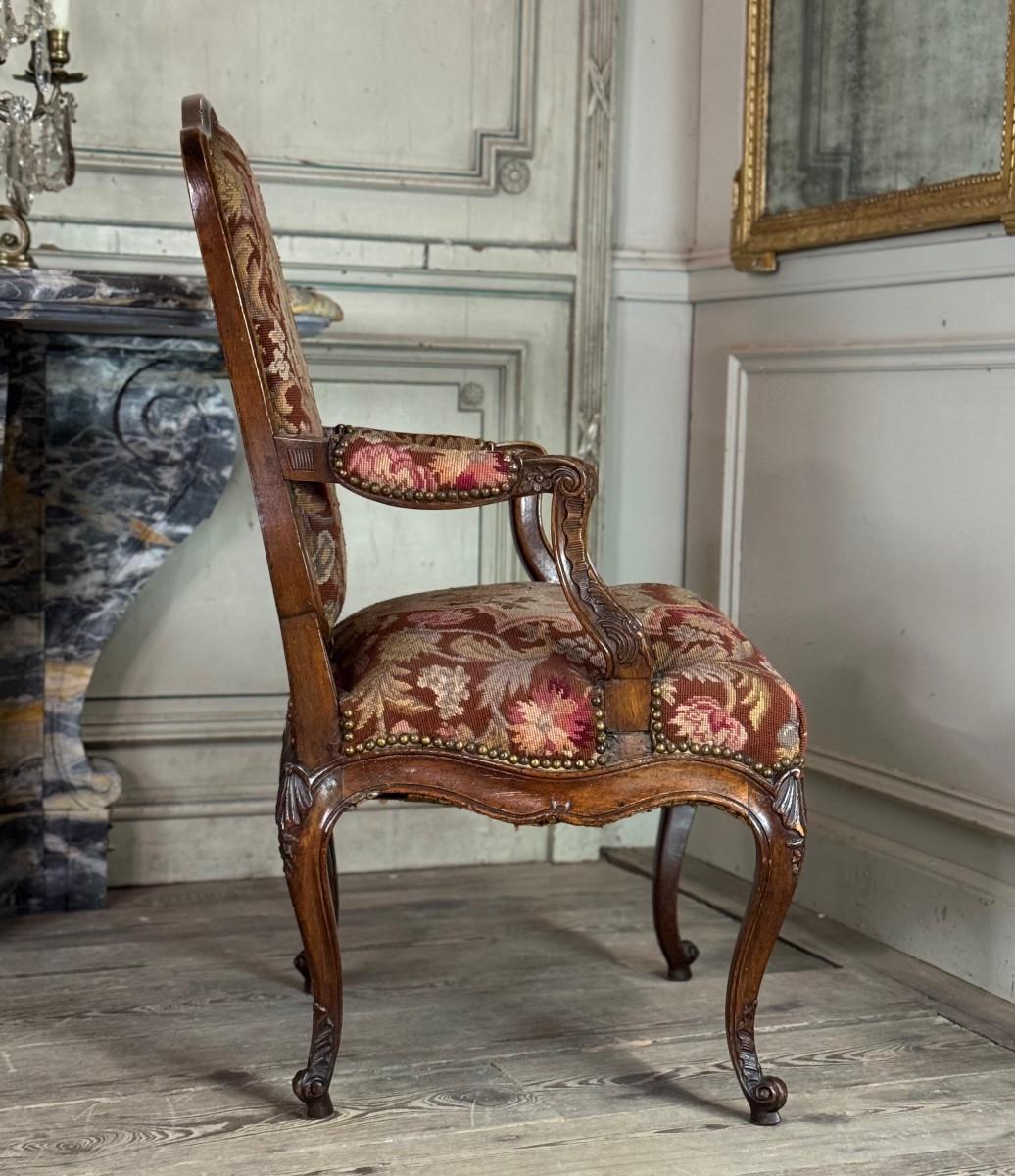 French Louis XV armchair in carved walnut, petit point tapestry, 18th century For Sale