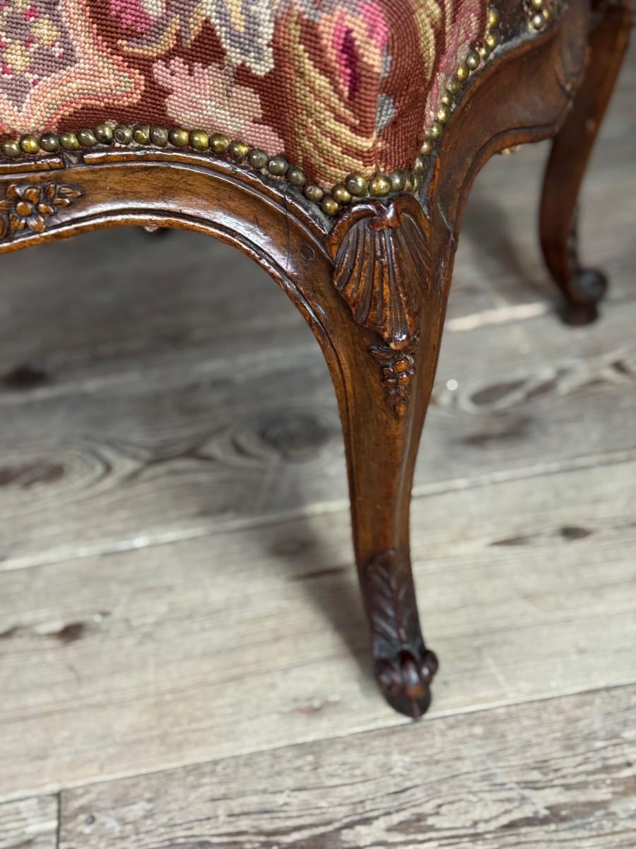 Wood Louis XV armchair in carved walnut, petit point tapestry, 18th century For Sale