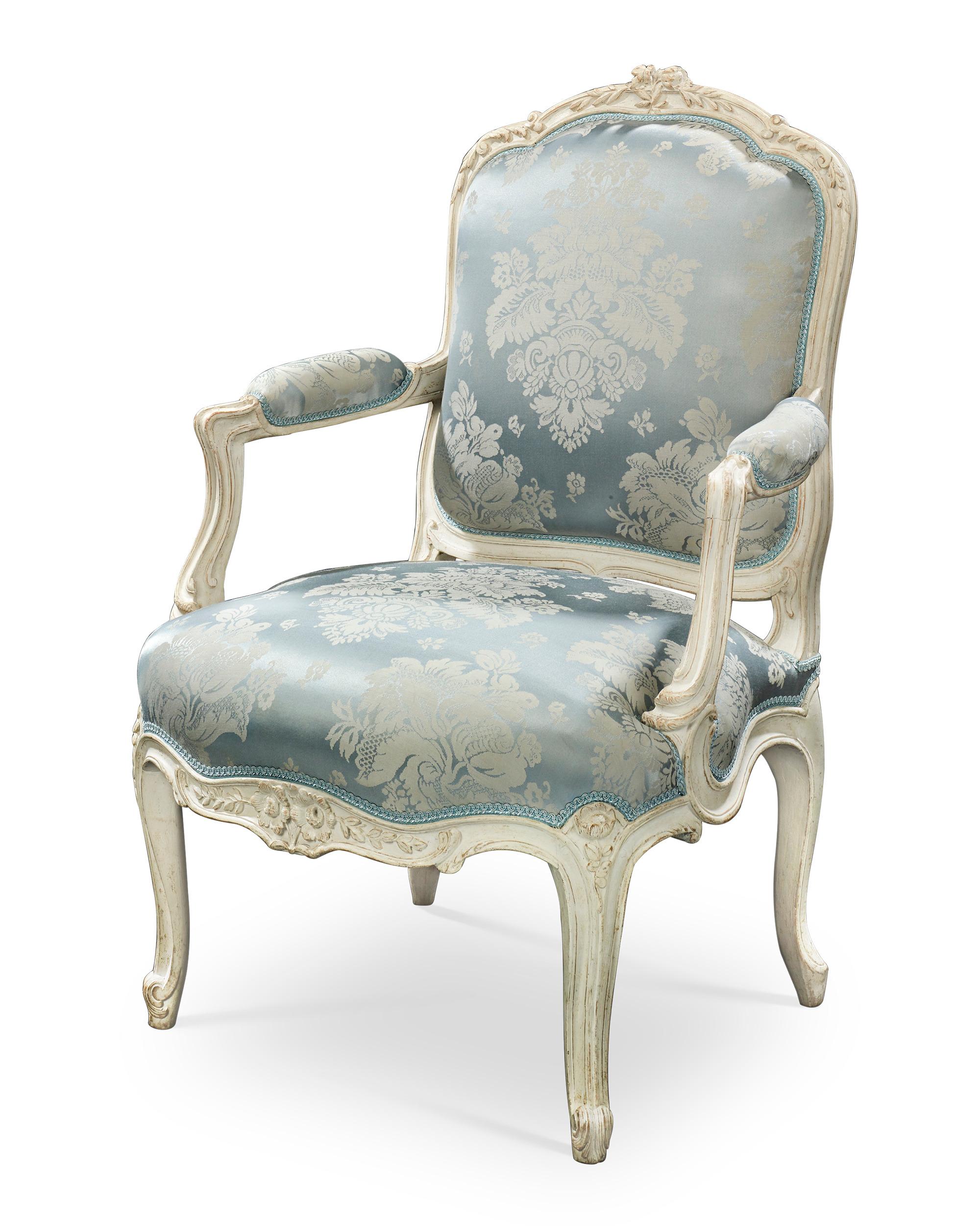This impressive pair of French armchairs displays the splendor and elegance of the Louis XV period. Crafted by the famed ébéniste Jean-René Nadal l'Ainé (1733-1783), the chairs are exquisitely constructed with graceful, curving lines and elegant