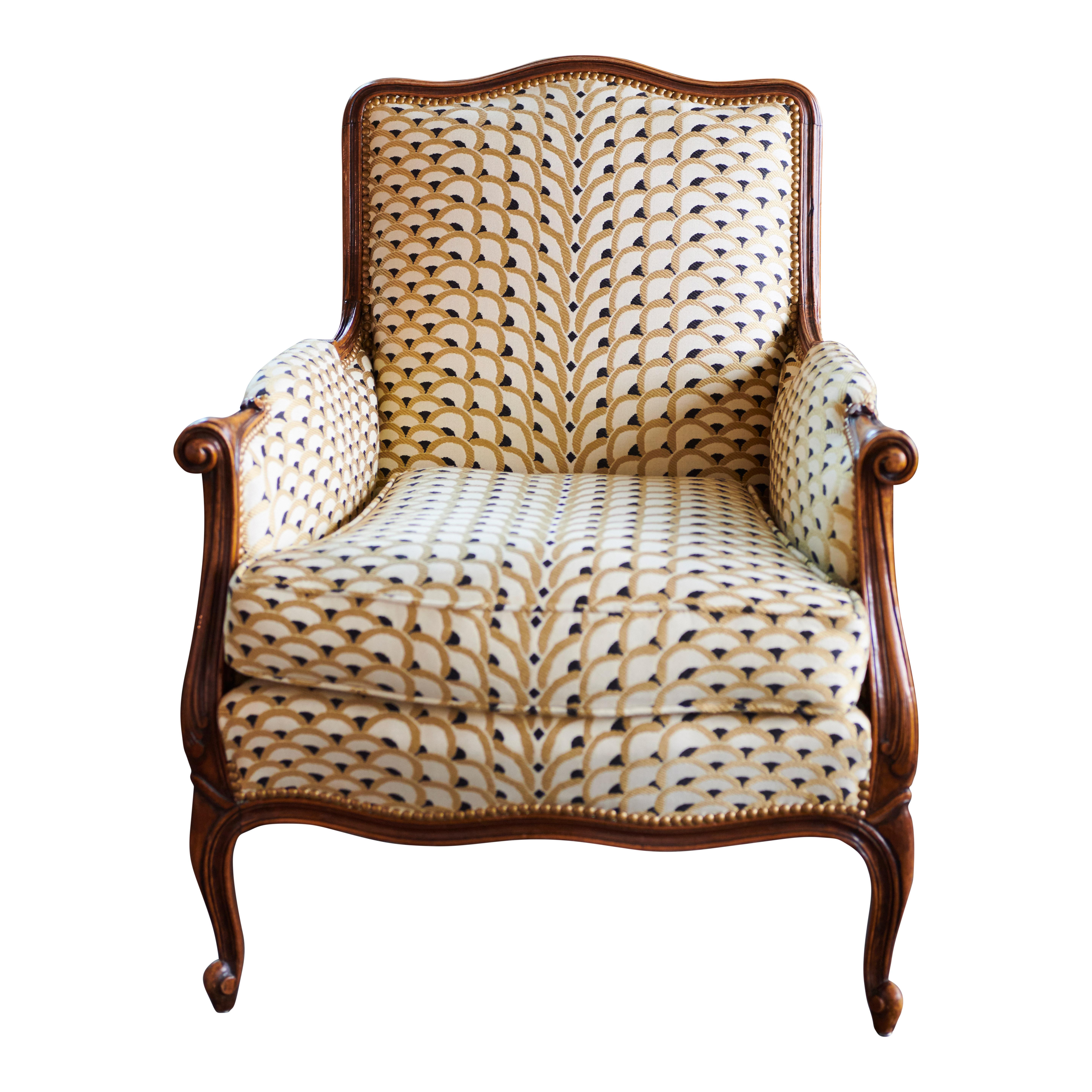 This is a so called Louis XV Bergère style chair. The chair is made from beech wood and has cabriole legs. The front has been upholstered with a new fabric Georges Le Manach Les Écailles from Pierre Frey. The back of the chair has been covered with