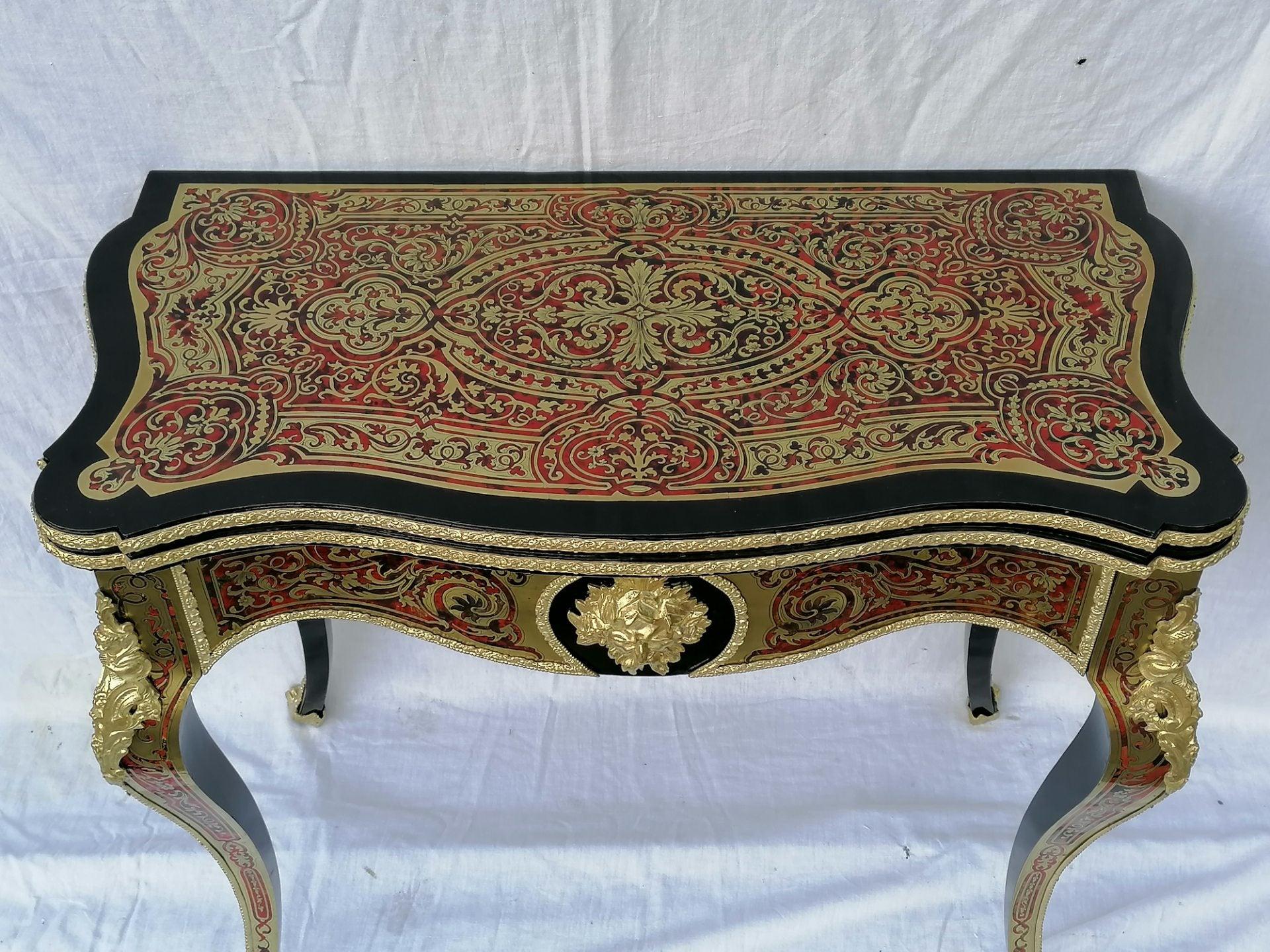Gorgeous Louis XV style game table, foldable, turning into a console table. In Boulle style Marquetry of red tortoiseshell on brass and golden bronze ornamentations. Almost entirely in Marquetry, even the in the inside part.
Important, the feutrine
