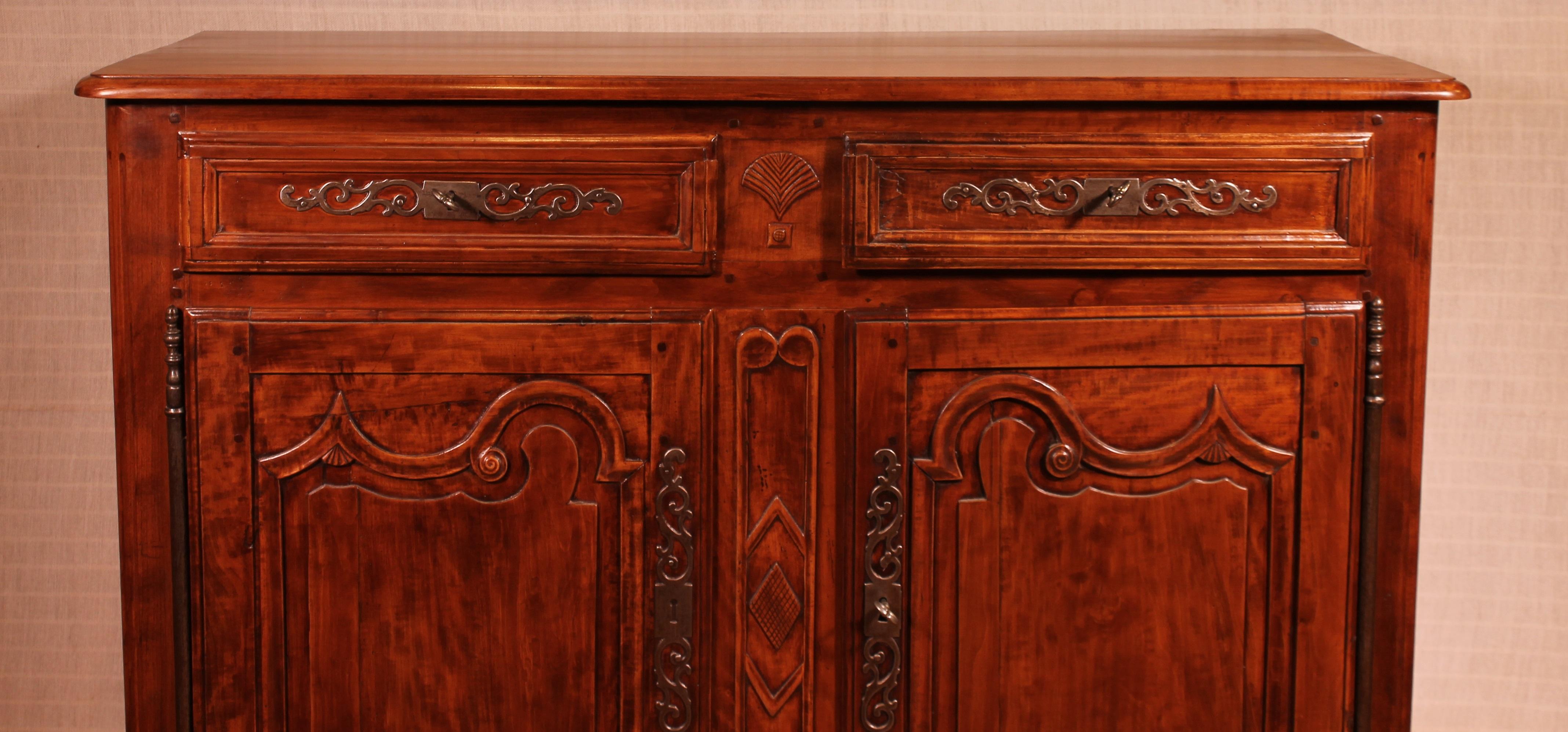 A fine Louis XV cherrywood buffet from the 18th century from France.

Very elegant credenza or buffet which opens with two large molded doors with asymmetrical carvings. Moreover, the buffet has two equally molded drawers

The sides of the