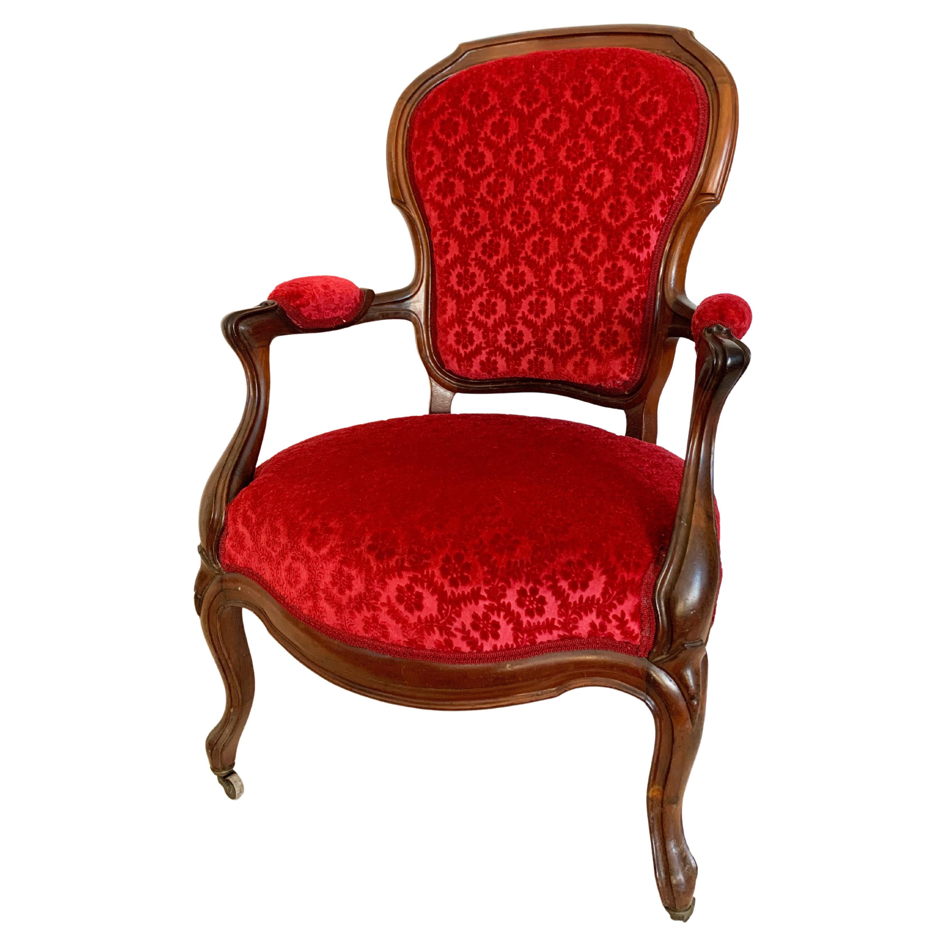 Beautifull Louis 15 mahogany cabriolet armchair from Louis-Philippe period. Its front legs are curved and end with casters. The armrests have volutes bringing a certain elegance. 
It has a beautiful red embossed velvet tapestry. 
France circa 1850.