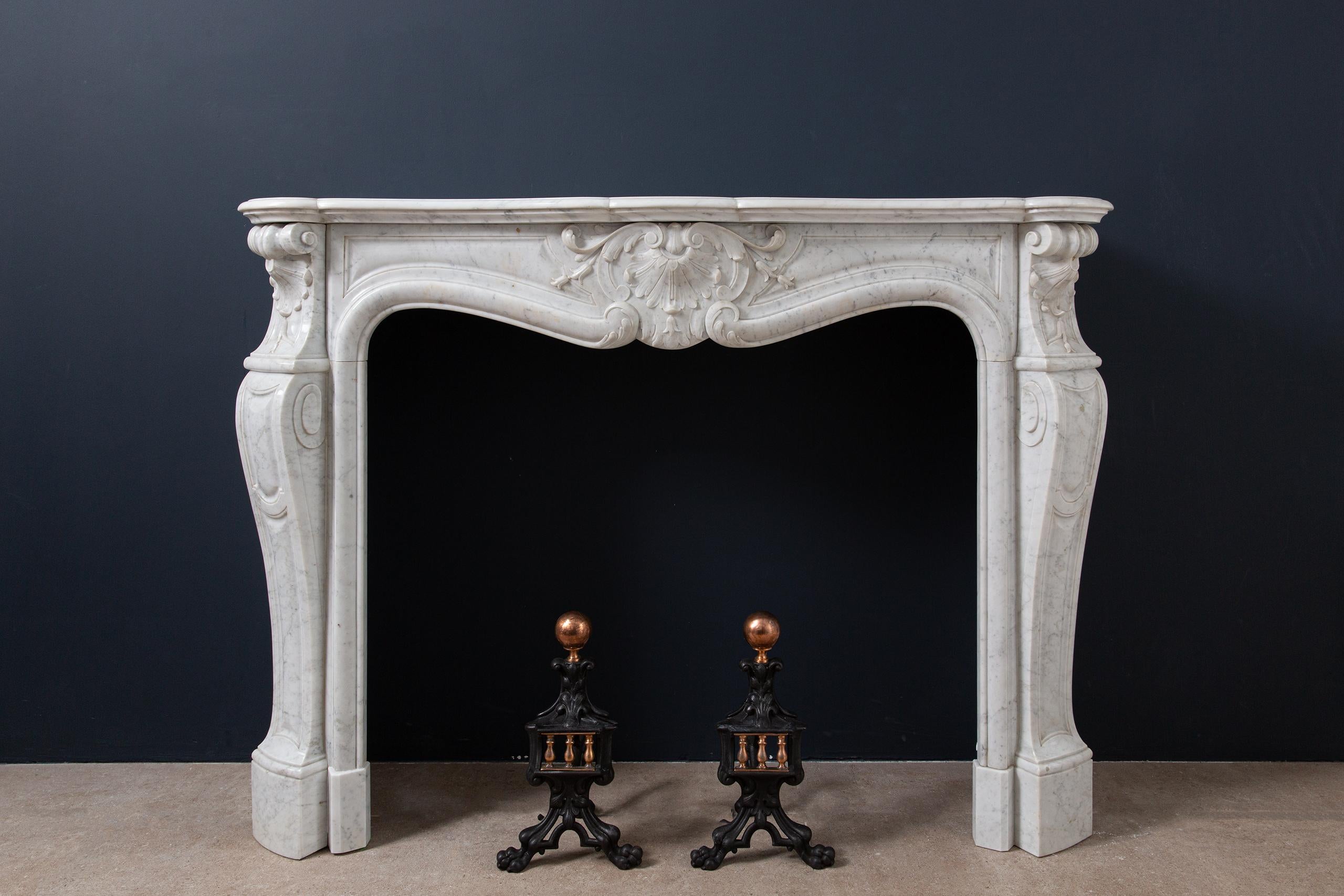 A beautiful antique fireplace in the typical Louis XV style, made of Carrara marble. With their French origin, these types of fireplaces are also called “trois coquille” fireplaces. The three cut shells spread over the linear width at the top of the