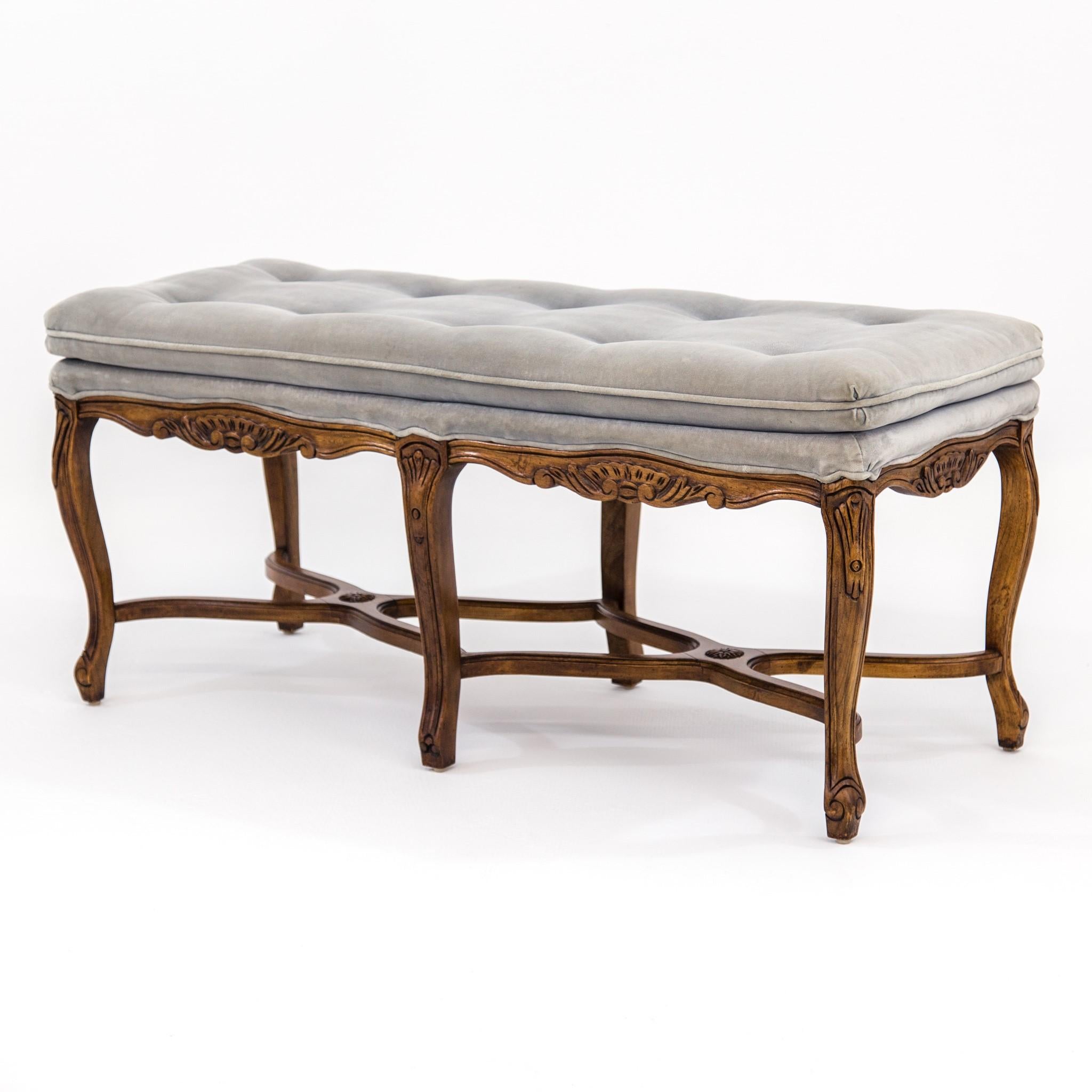 1960s Louis XV-style carved walnut bench or window seat with button tufted upholstery, cabriole legs and curved X stretchers by Bernhardt Flair Division. The original velvet fabric is light gray with teal undertone. The carved walnut frame has an