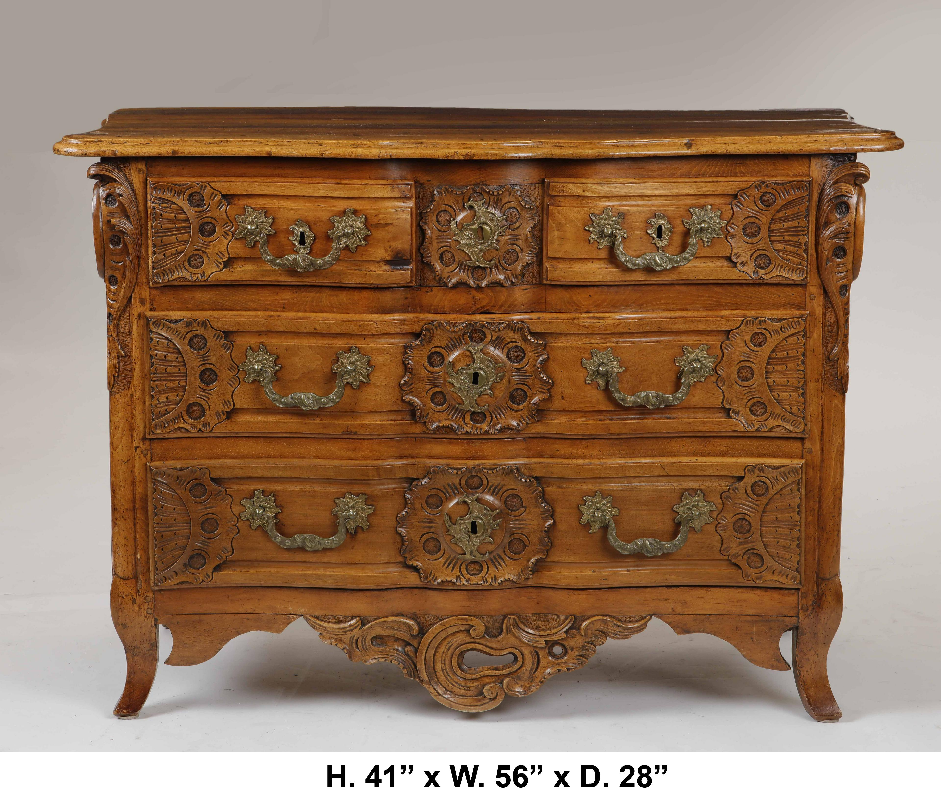 Exceptional 18th century Louis XV Provincial finely carved walnut commode.
The molded shaped top is above two short drawers and two long drawers, each drawer is mounted with rosettes conjoined by an in-curved gilt bronze handle and centered by a