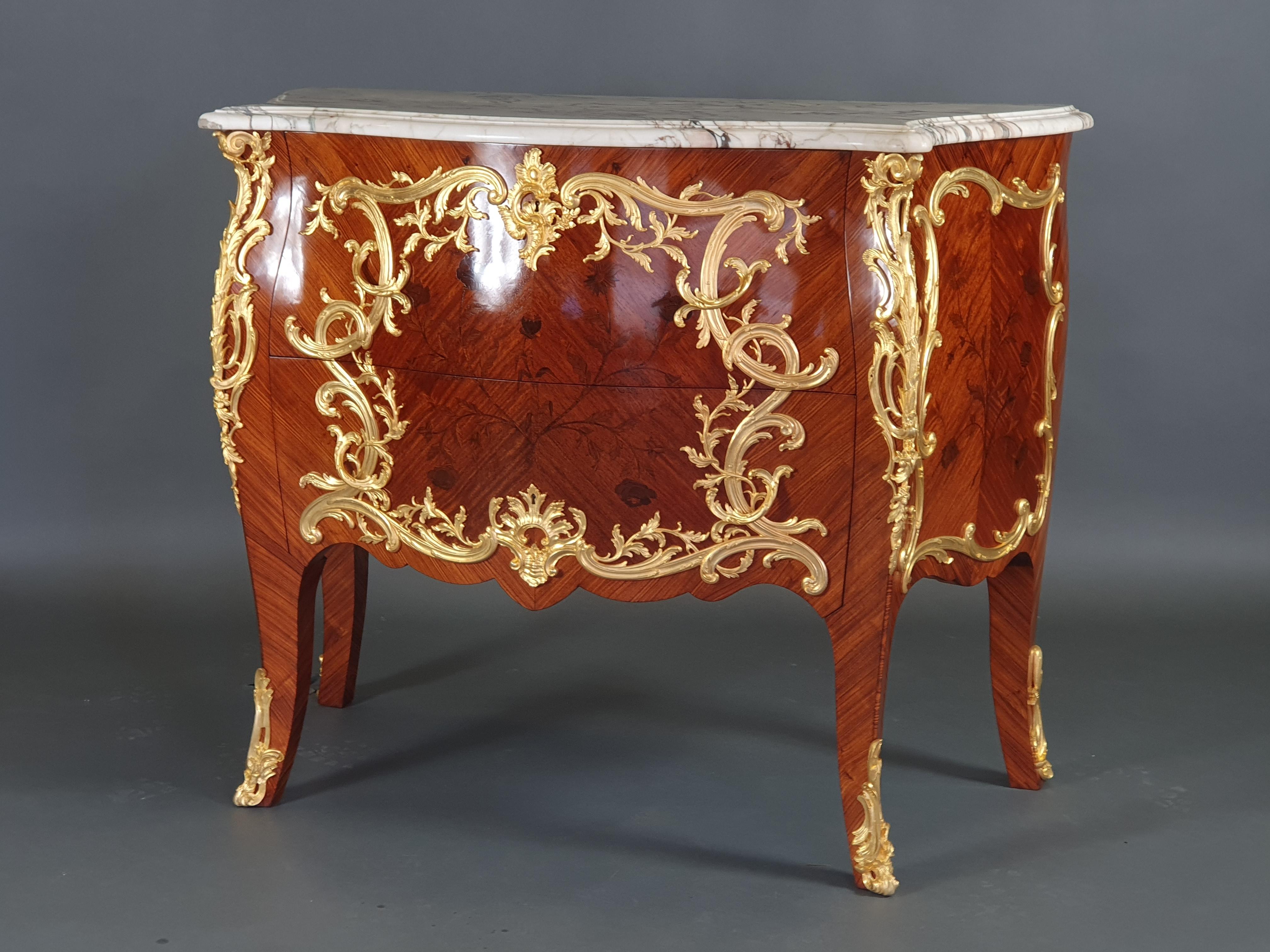 Superb Louis XV commode in the style of Charles Cressent, in floral marquetry in rosewood frames; exceptional ornamentation of very finely chiseled gilt bronze; beautiful veined white marble top molded in double corbin beak.
Opening two drawers