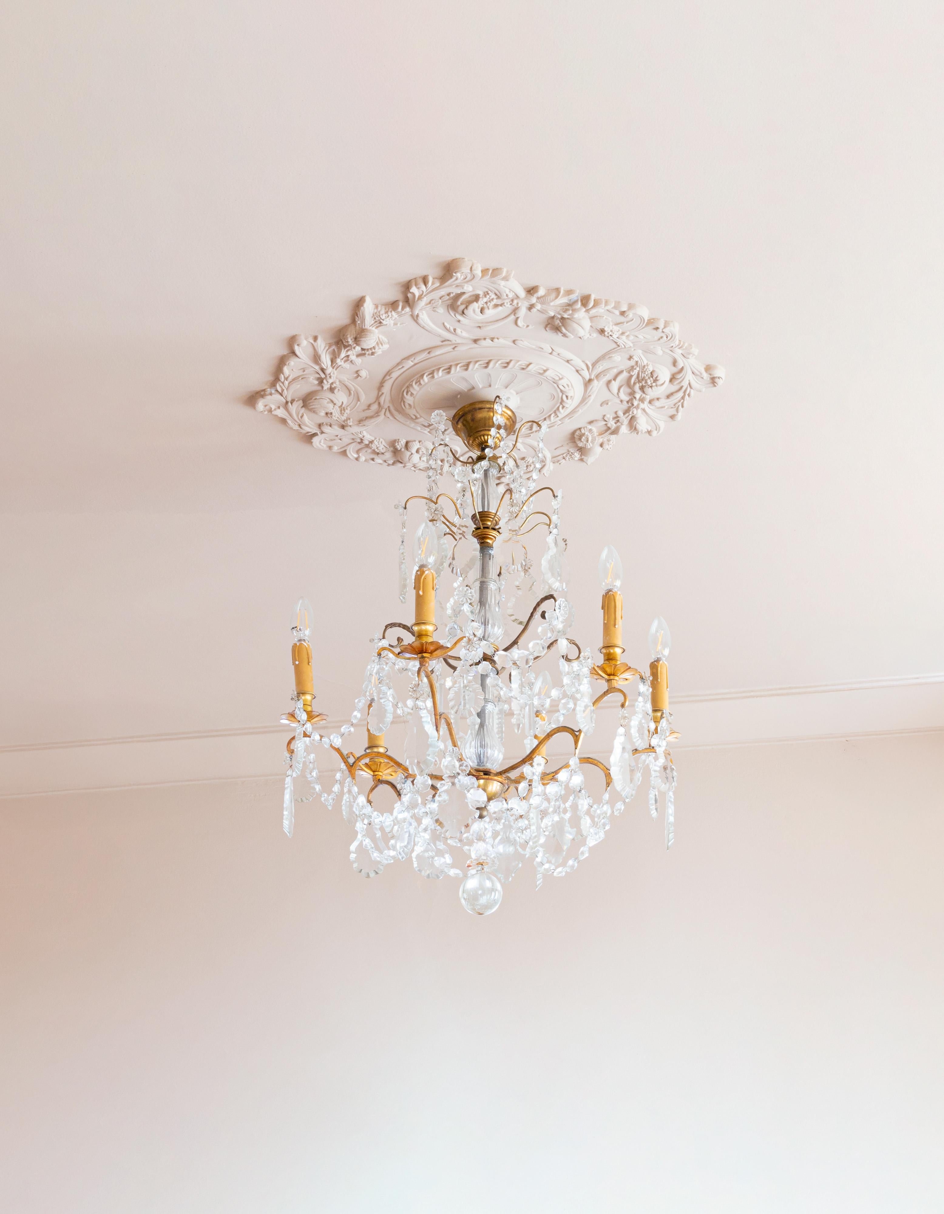 Araña francesa de estilo Luis XV fabricada en bronce y cristal.
Presenta seis elegantes portavelas junto con una variedad de colgantes y remates. 

Esta exquisita lámpara de araña del siglo XIX ha sido completamente recableada y viene con seis tomas