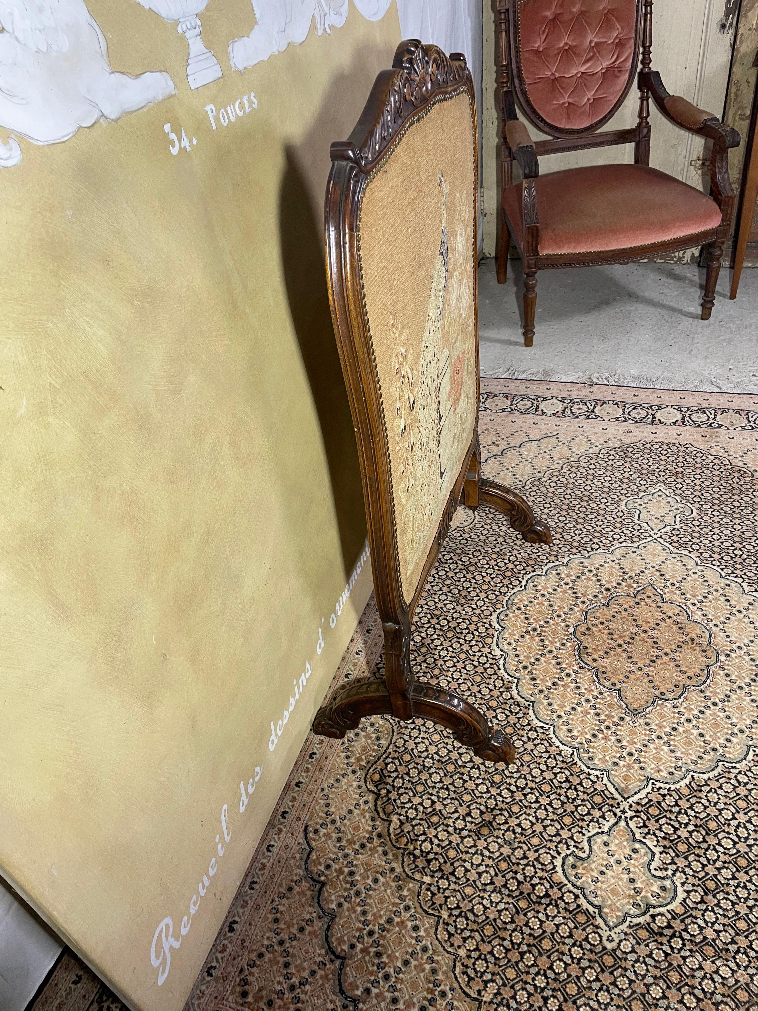 Elegante parafuoco bifacciale Luigi XV con intricato arazzo a punto d'ago.
Questo parafuoco in stile Luigi XV della fine del XIX secolo è un pezzo decorativo raro e sofisticato, caratterizzato da un design a doppia faccia con due splendidi arazzi