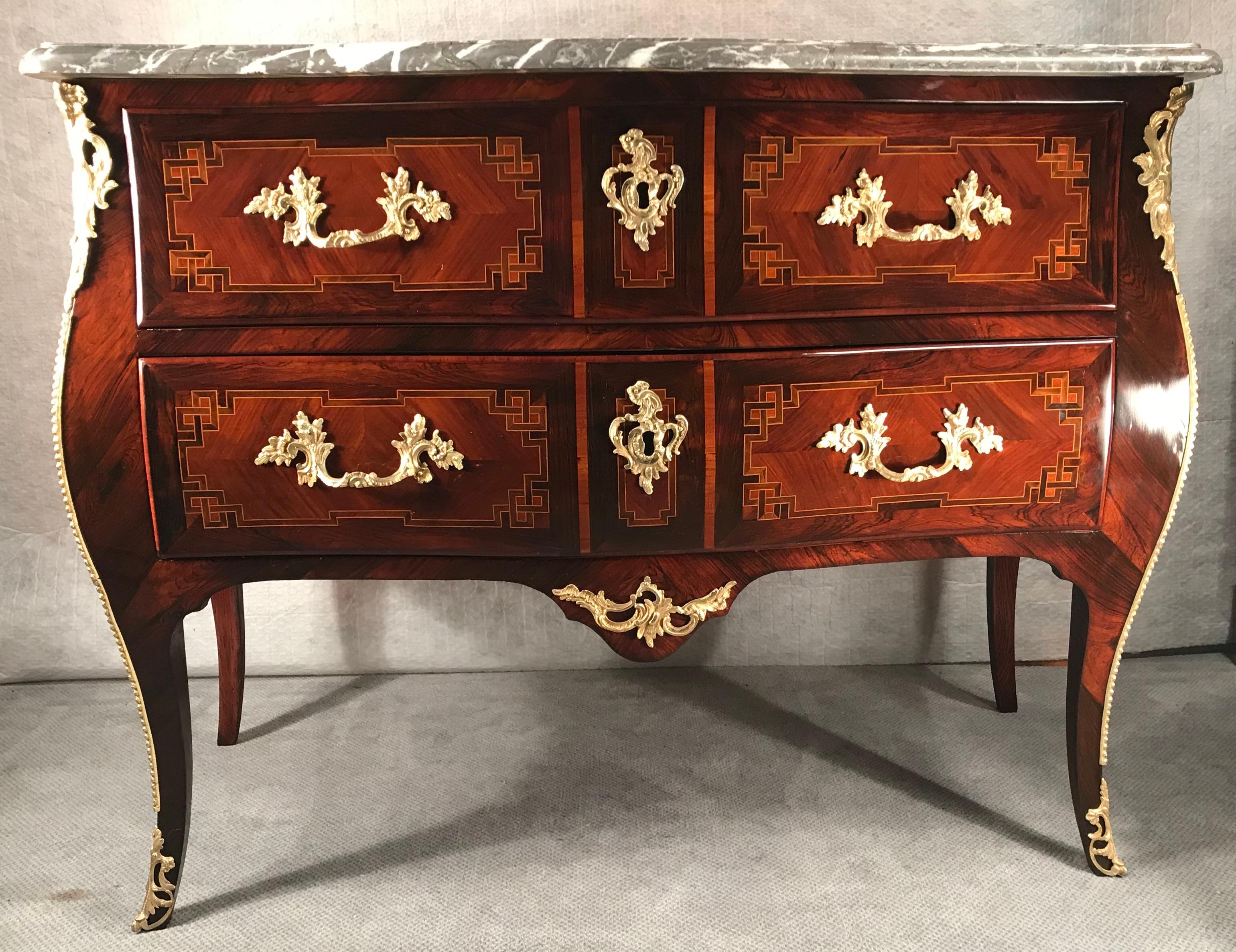 Commode Louis XV, France 1770.
Cette commode unique a été fabriquée dans la période entre Louis XV et Louis XVI. 
Elle possède toujours les courbes gracieuses et les ferrures en bronze richement décorées du style rococo, mais le motif de la