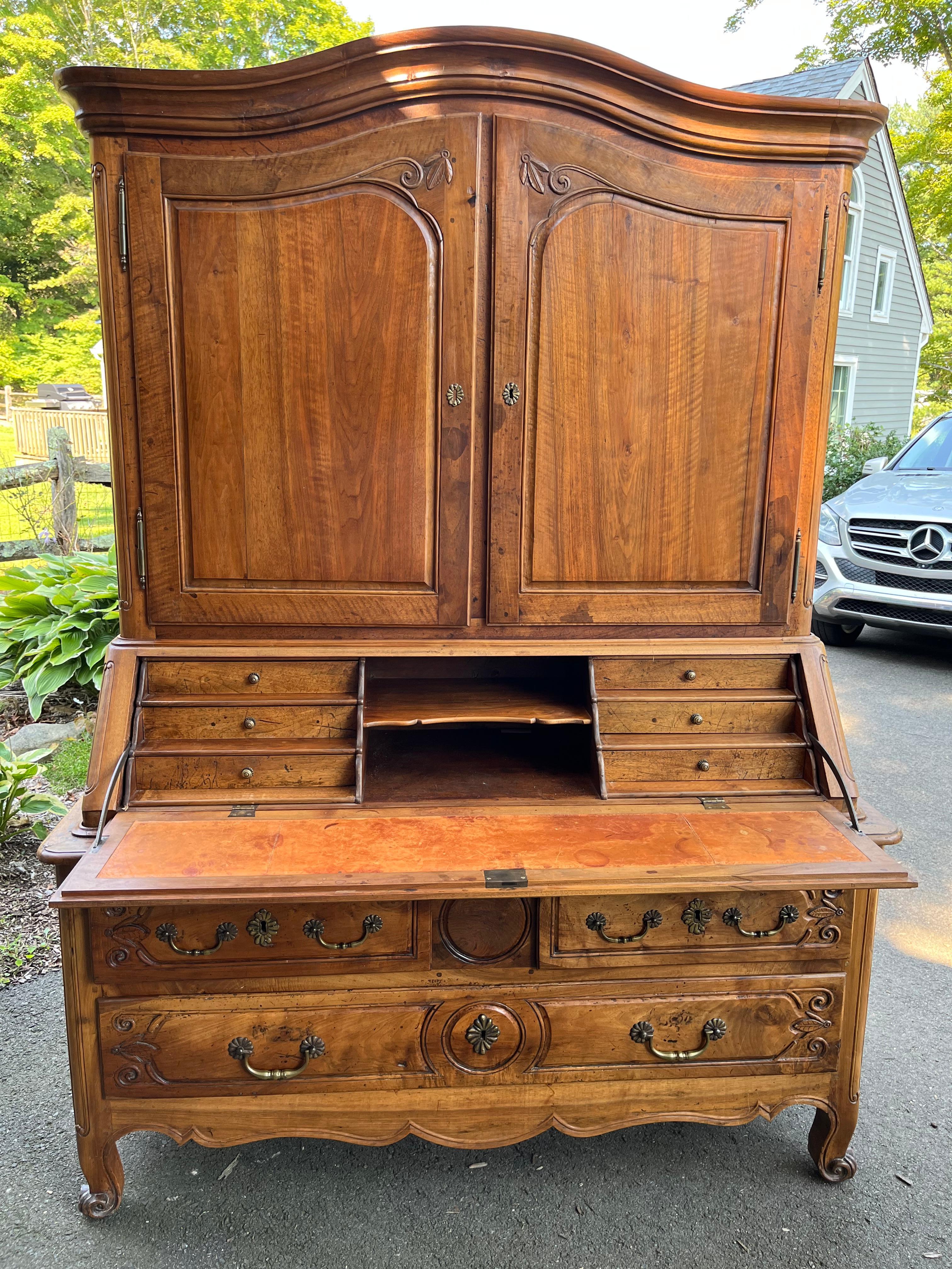 A very nice Louis XV slant-front secretaire desk in walnut, with a 3-drawer lower cabinet under a fitted fall-front desk with inset leather writing surface, under a 2-door arched cabinet top with molded crown. In three sections for easy moving.