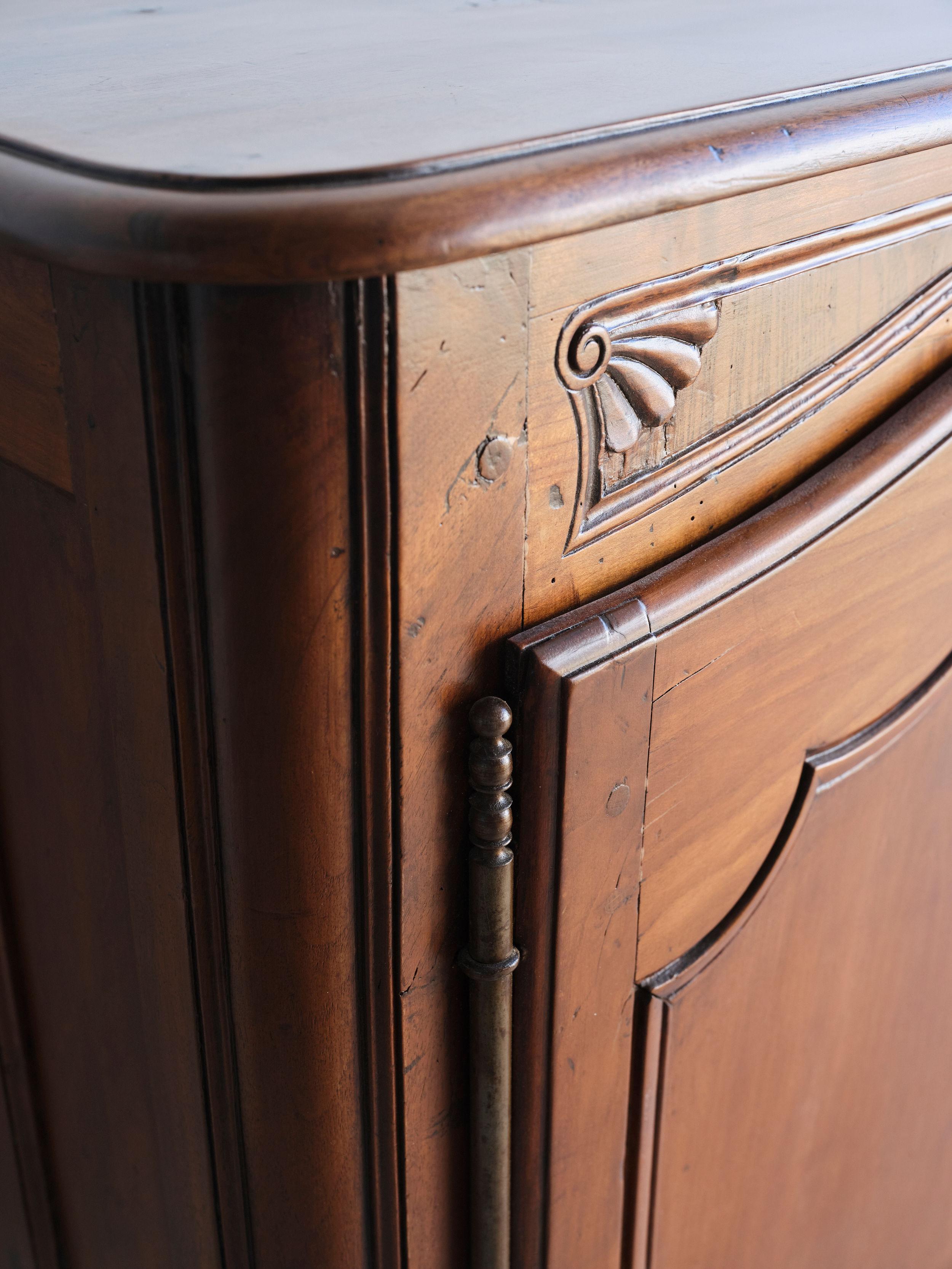 This stunning 18th century Louis XV style enfilade features a warm patina stain and beautiful hand carved details. There are 4 small central drawers and two outside cabinet doors that open to an interior shelf on each side. All of the hardware is