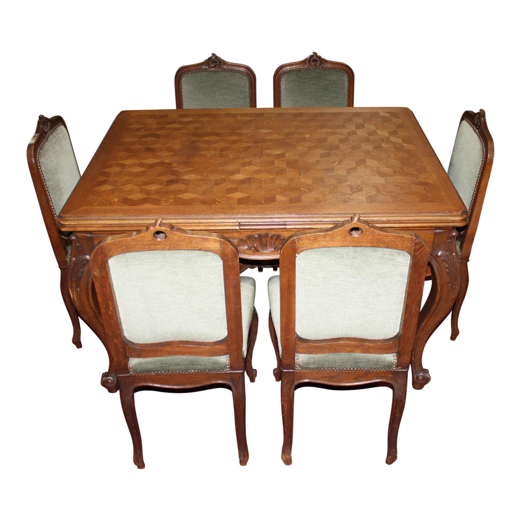 Comprised of a beautiful parquet table and six upholstered chairs, this elegant, oak, Louis XV dining set offers flexibility to extend the length of the table when the table's sliding leaves are pulled out. The table features a beveled edge around