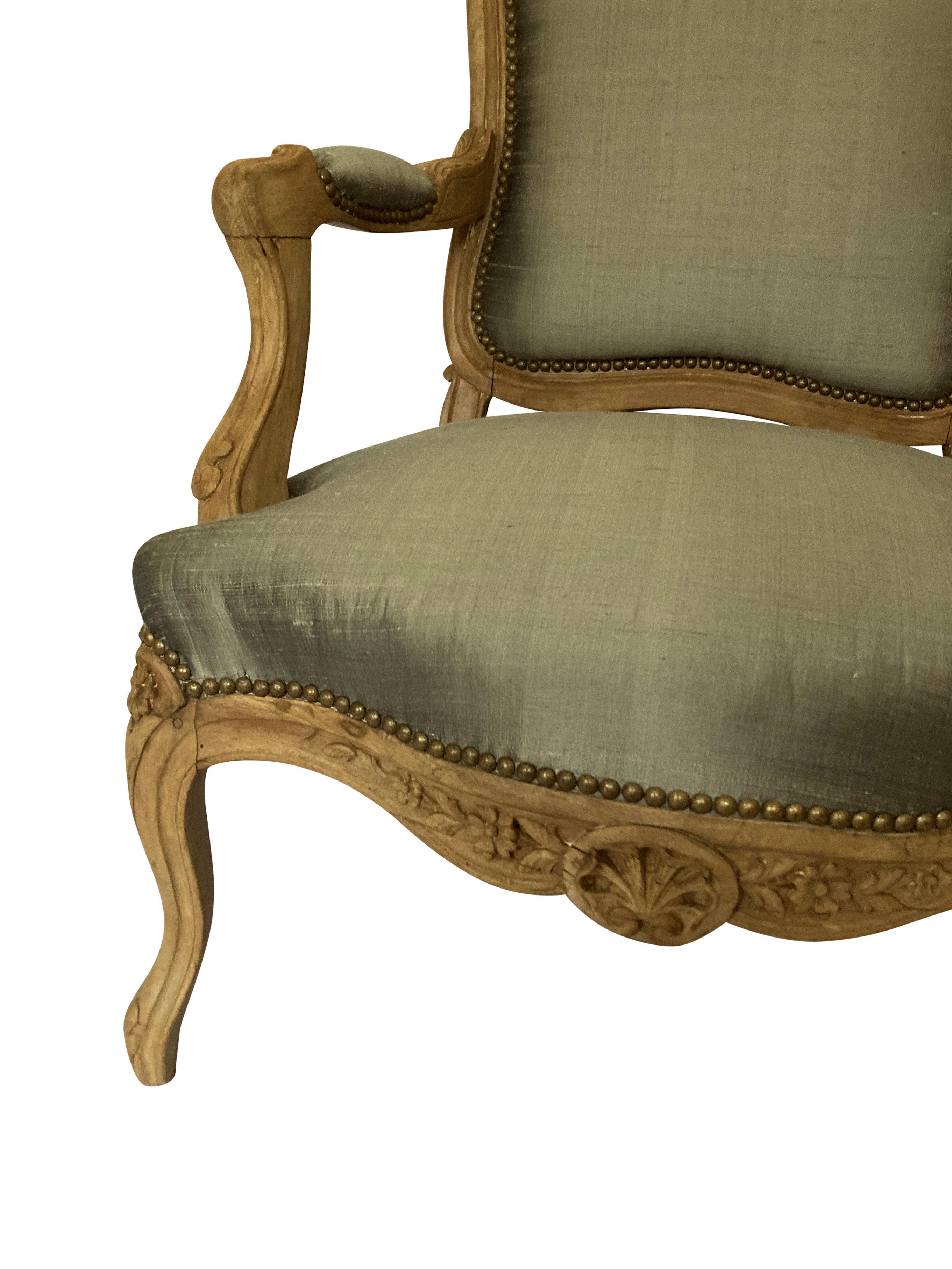 A French Louis XV Fauteuil A La Reine in fruitwood. Beautifully carved with a good patina, newly upholstered in a stone coloured textured silk.