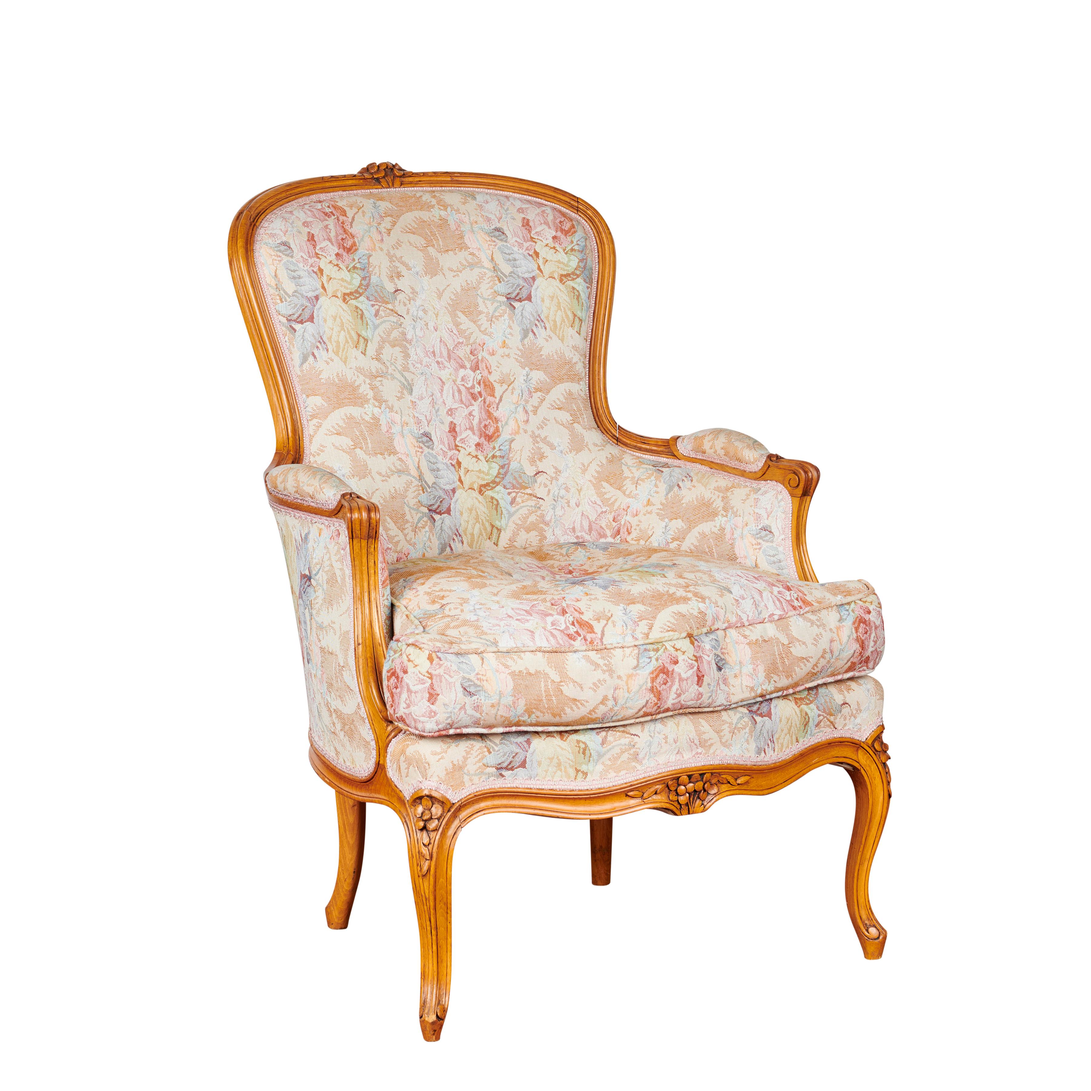 These beautiful circa 1980 French cherrywood armchairs and foot rest (3-piece set), are a comfortable and stylish accompaniment to any fine lounging area. They feature ornate fleur detailing scattered throughout the upholstery, with Louis XV style