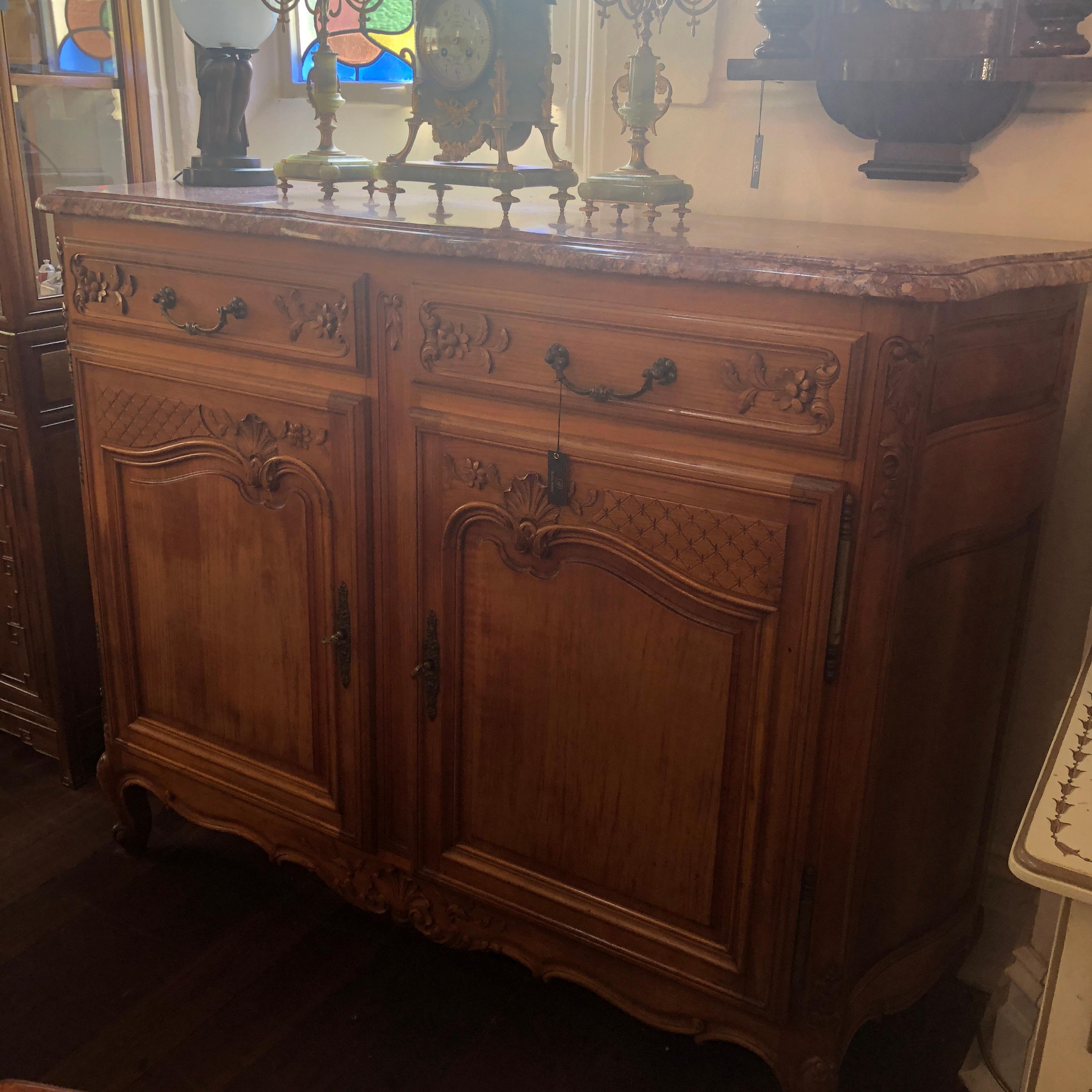 The most charming commode for the Province styled home, this delightful Louis XV carved commode, features a lovely ochre veined marble top and cherry wood body. Dated at approximately circa 1930, this piece features a distressed patina with cabriole