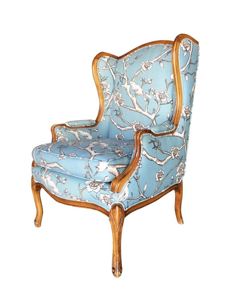 Vintage pair of French country inspired walnut wing back lounge chairs. The chairs feature a hand carved frame with blue floral fabric upholstery,

circa 1950.