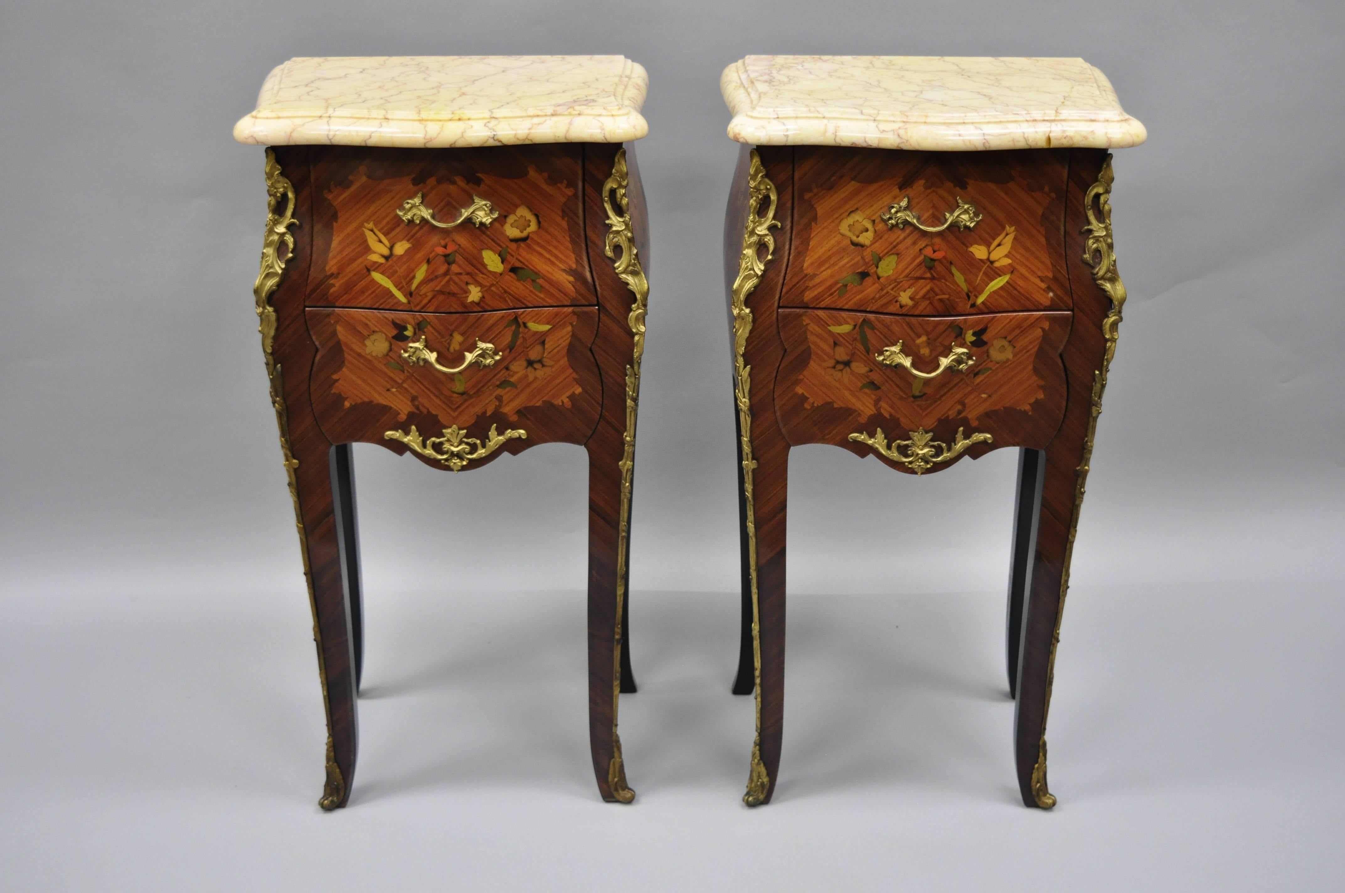A pair of Louis XV French style bombe form floral inlaid marble-top nightstands. Item features bronze ormolu, floral satinwood inlay, shaped marble top, two dovetailed drawers, cabriole legs, great style and form, circa late 20th century.