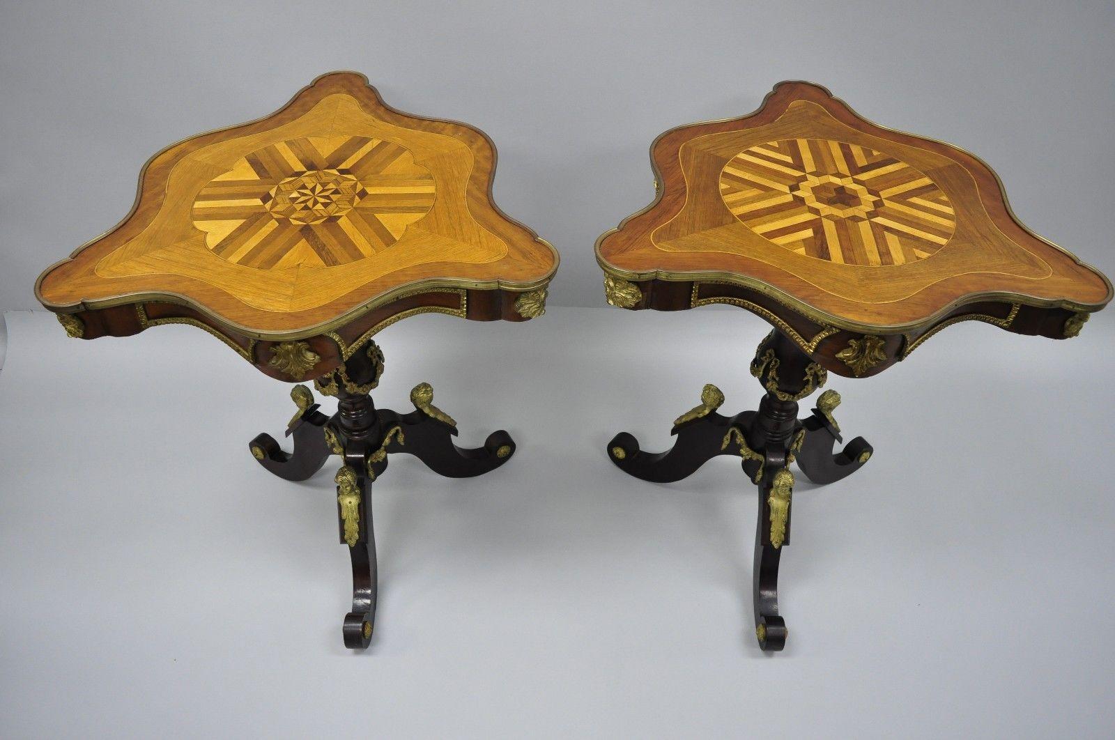 A Pair Louis XV French Style Reproduction Marquetry Inlaid Side Tables with Bronze Figures. Item features bronze ormolu with female faces, marquetry inlaid triangular tops, pedestal base, cabriole legs, great style and form. Circa Late 20th Century.
