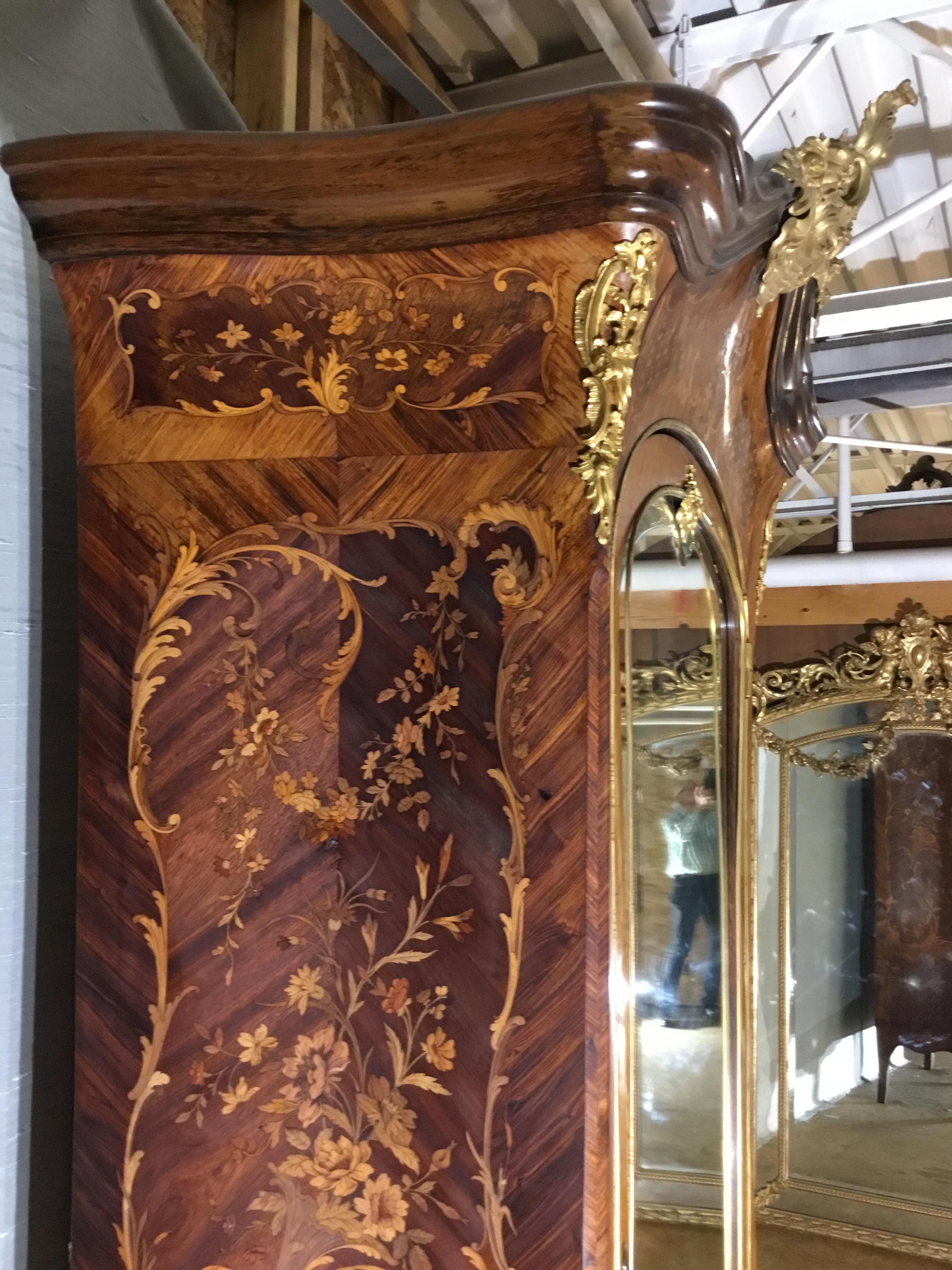 This elegant piece is a Louis XV gilt bronze mounted armoire in kingswood with fruitwood marquetry in vines and flowers on gilt bronze cuffed cabriolet legs.

This outstanding armoire is representative of the great craftsmanship demonstrated by