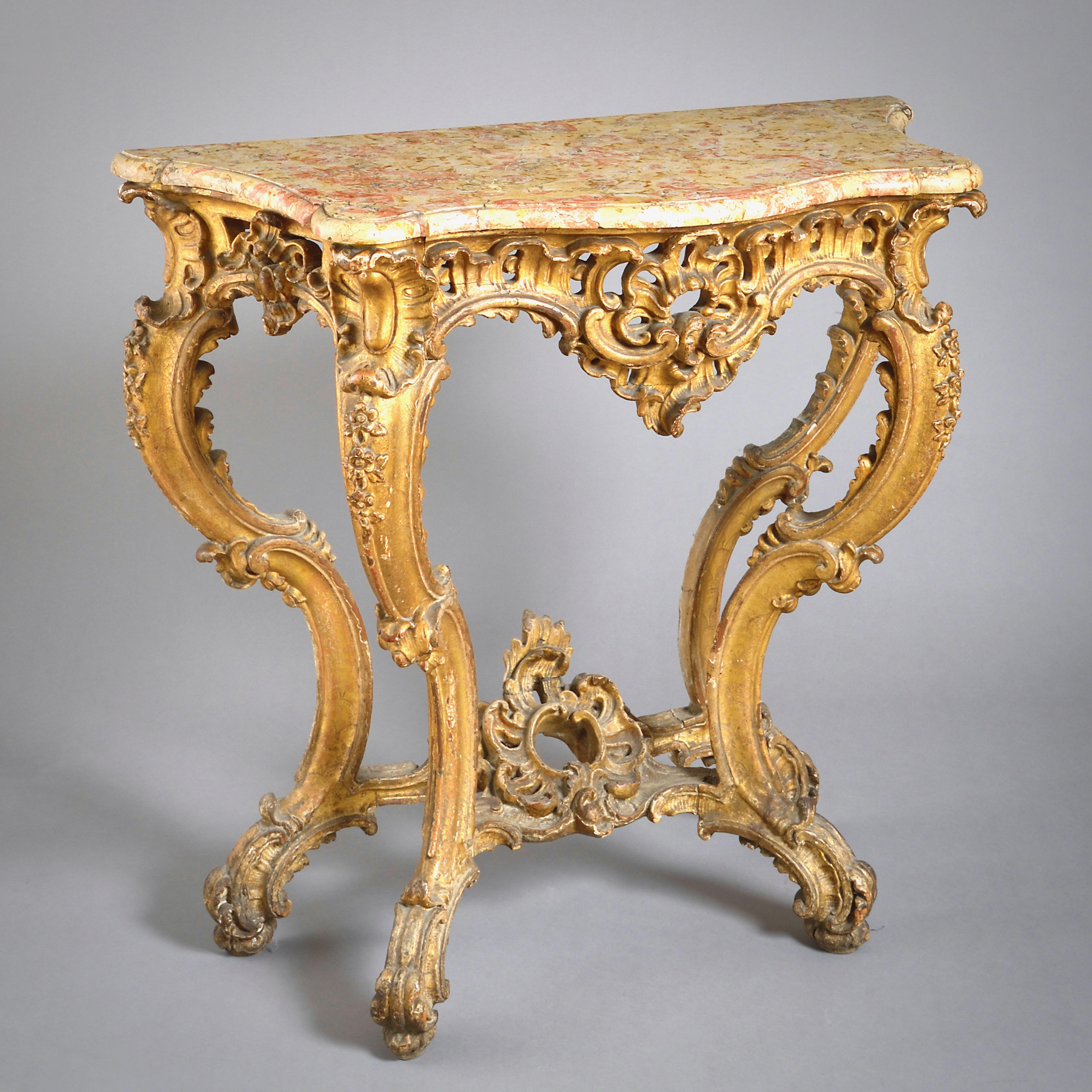 A Louis XV carved gilt-wood console table, 1740.

With original mottled limestone top. The gilding also original.