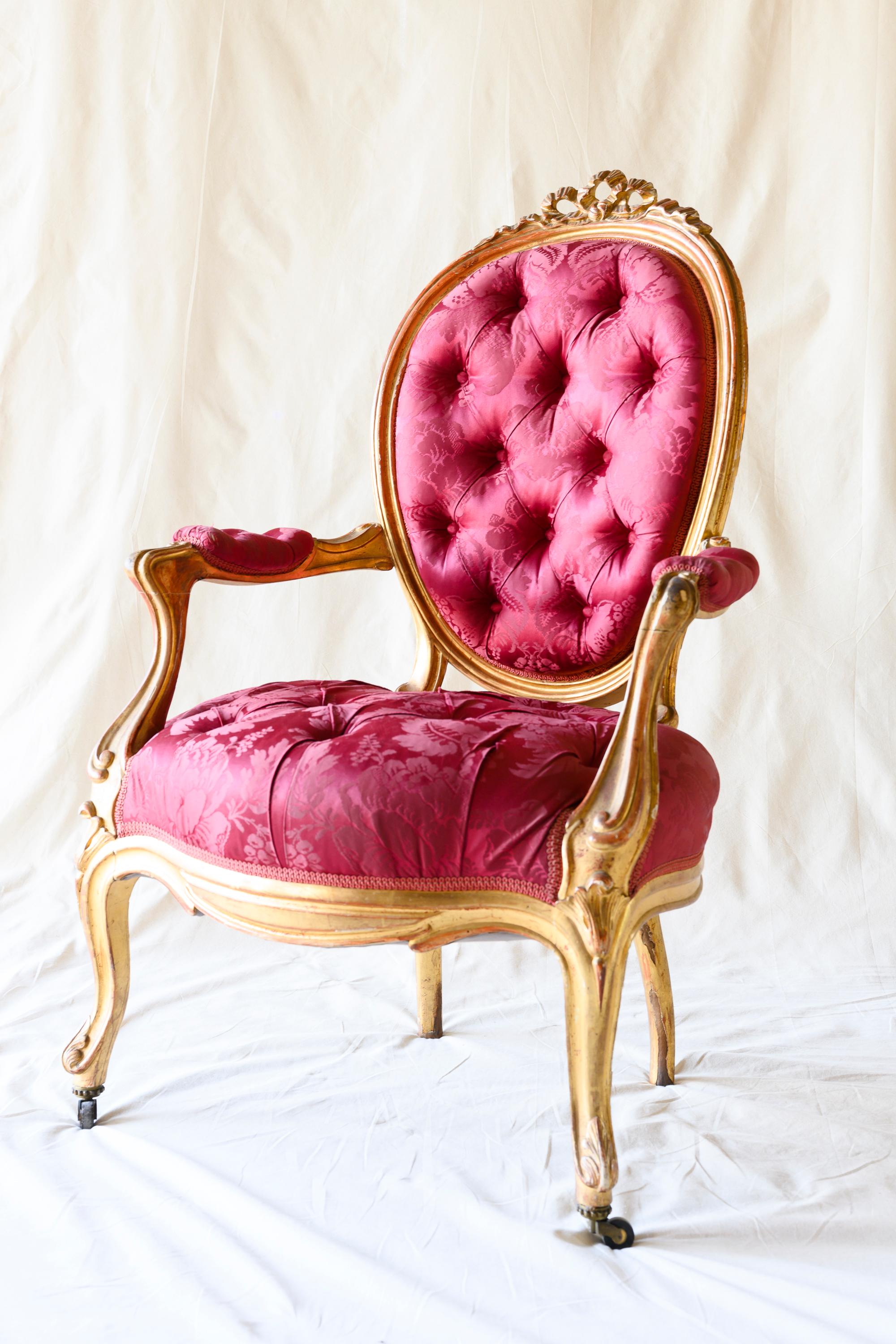 Suite of four Louis XV style giltwood cabriolet armchairs, featuring a comfortable curved round backrest topped by carved ribbons, molded serpentine rails leading to open armrests supported on cabriolet legs, upholstered seat and backrest with