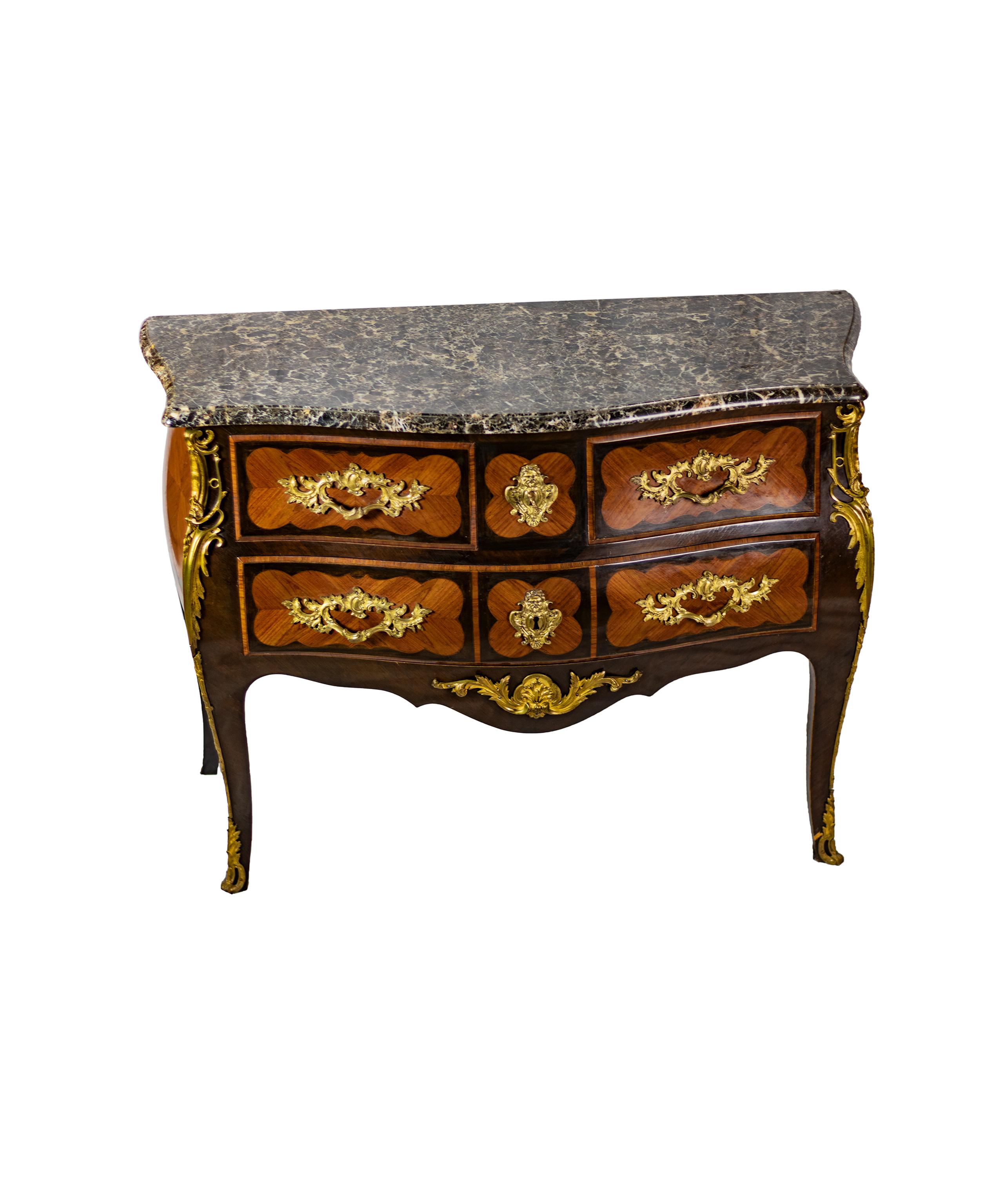 A kingwood commode with a bombé front, two drawers spanning the full width of the piece, and two smaller drawers above, tapering legs with scrolled caps, characteristic of Louis XV, finely grained rosewood and kingwood veneer and gold-plated bronze