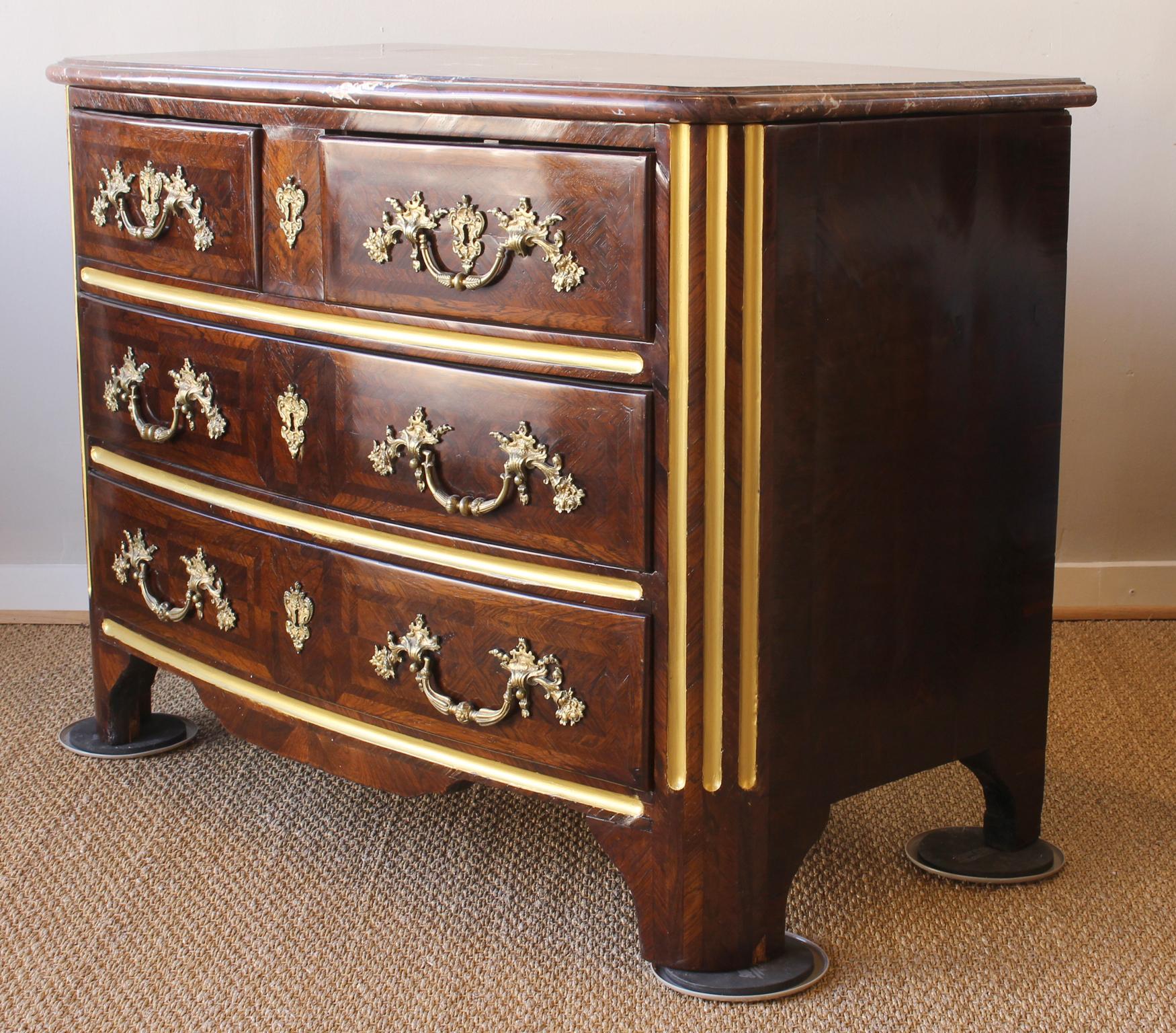 An elegant Louis XV three-drawer kingwood commode with gilt bronze pulls and rouge marble-top.
