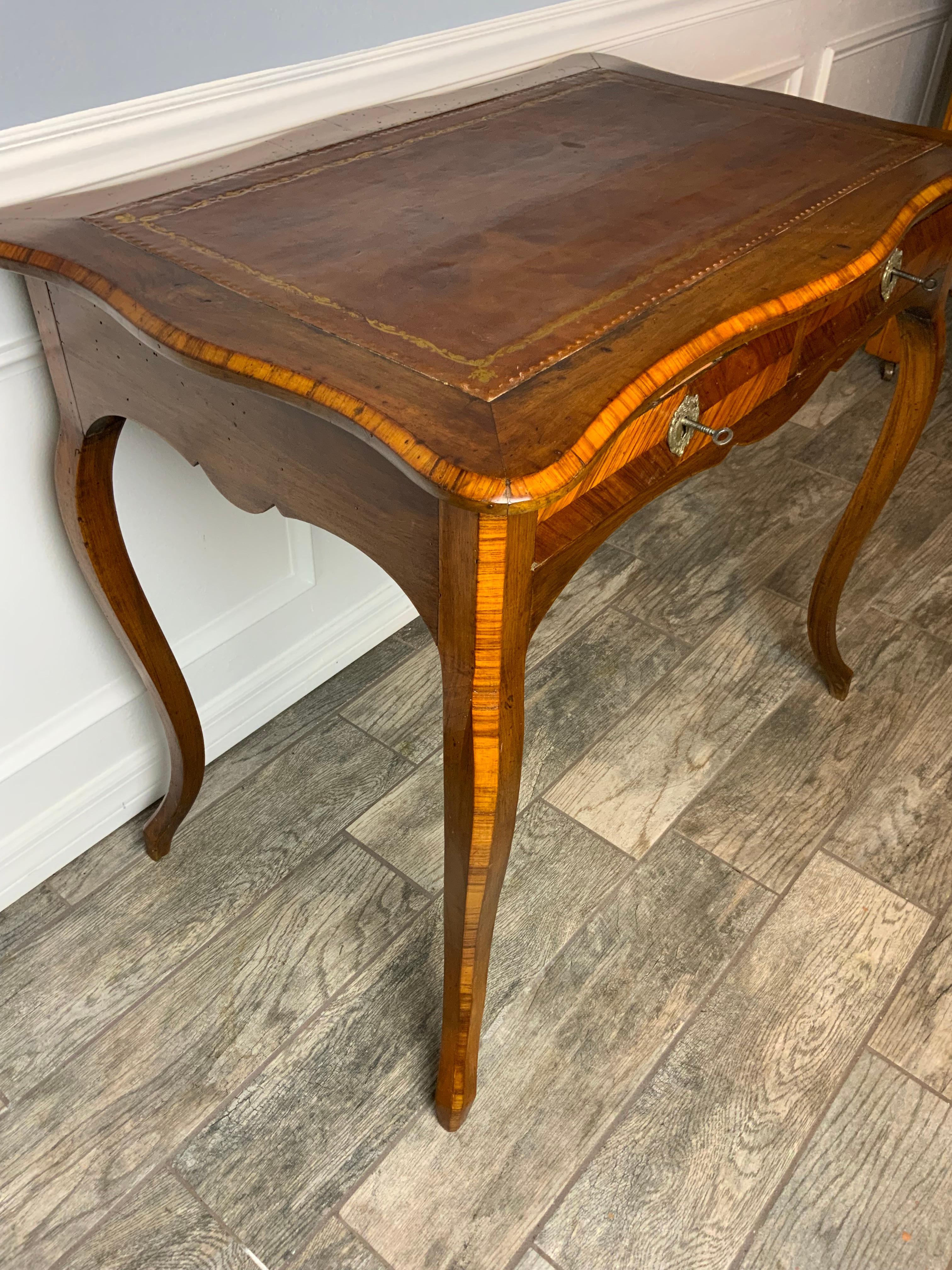 A very nice 18th century Walnut and Tulipwood leather top French writing desk. This is a beautiful petite size piece made of French Walnut with Tulipwood cross banding on the top edge, drawer faces, and down the fronts of the legs. Excellent color