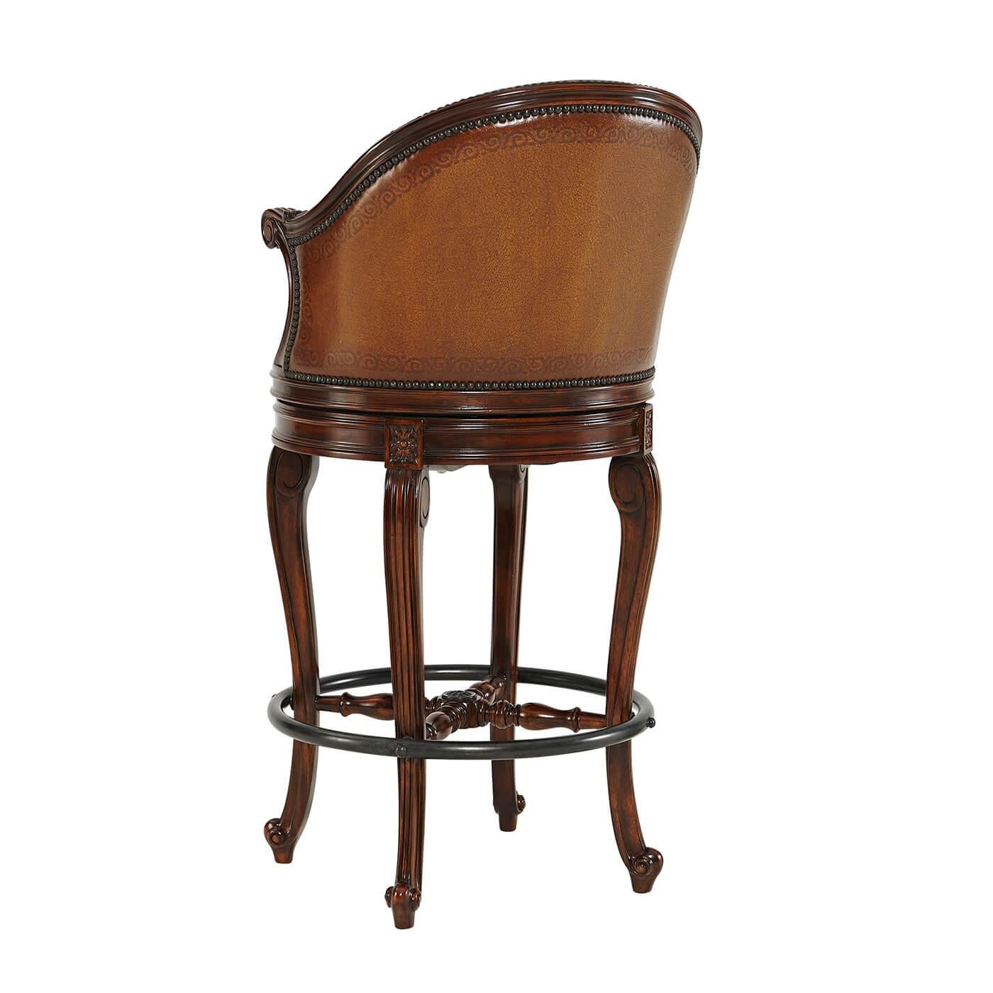 A French Louis XV style hand carved scoop back swivel bar stool, the padded scoop back and upholstered tooled leather seat and back, with scroll arms and legs and a verdigris brass footrest. 

Dimensions: 22