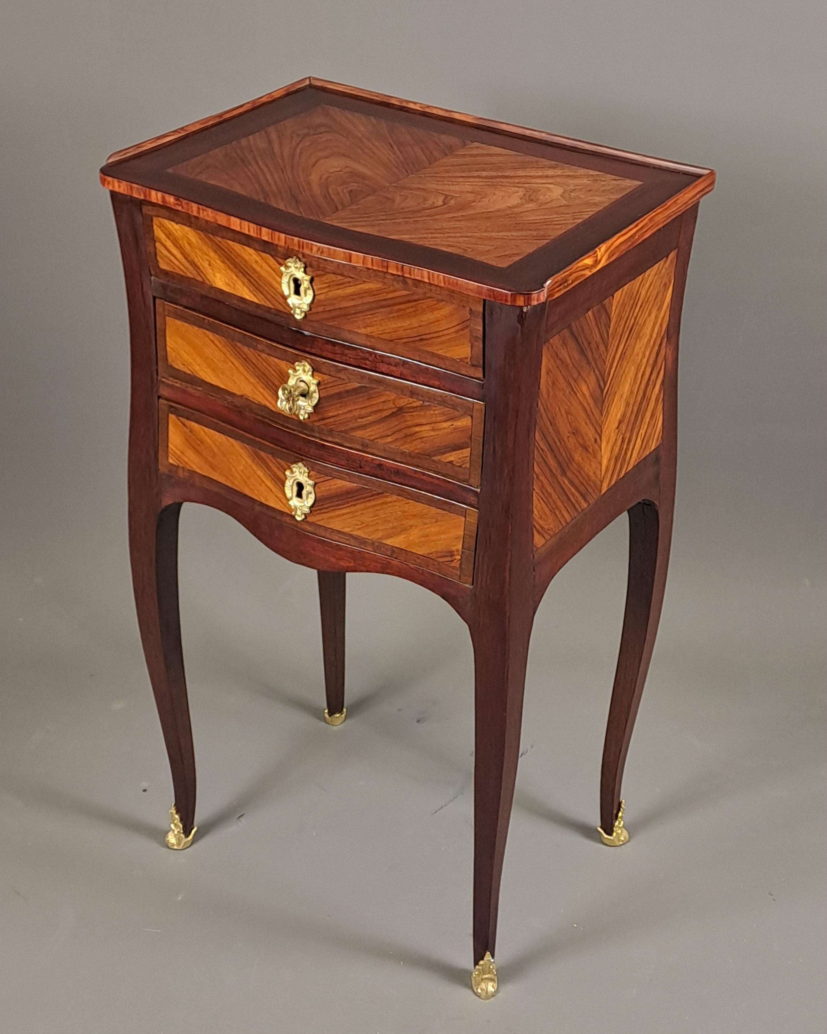 Louis XV coffee table in amaranth veneer and rosewood reserves presented in chevrons on four sides as well on the top.

Four elegantly arched legs.

Opening 3 drawers on the front, including the top one with compartments.

Functional and original