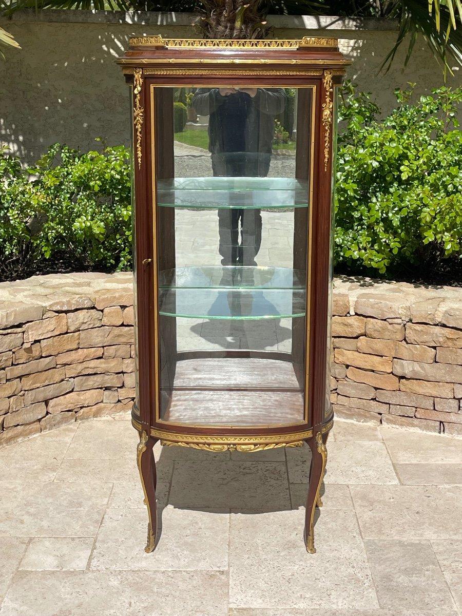 Vetrina in stile Luigi XV in mogano e bronzo dorato con un'anta con vetro curvo. All'interno ci sono due ripiani in vetro. Opera francese del 1880/1900 circa. 

Dimensioni
Altezza totale: 1m49 
Larghezza: 66 cm 
Profondità: 46 cm