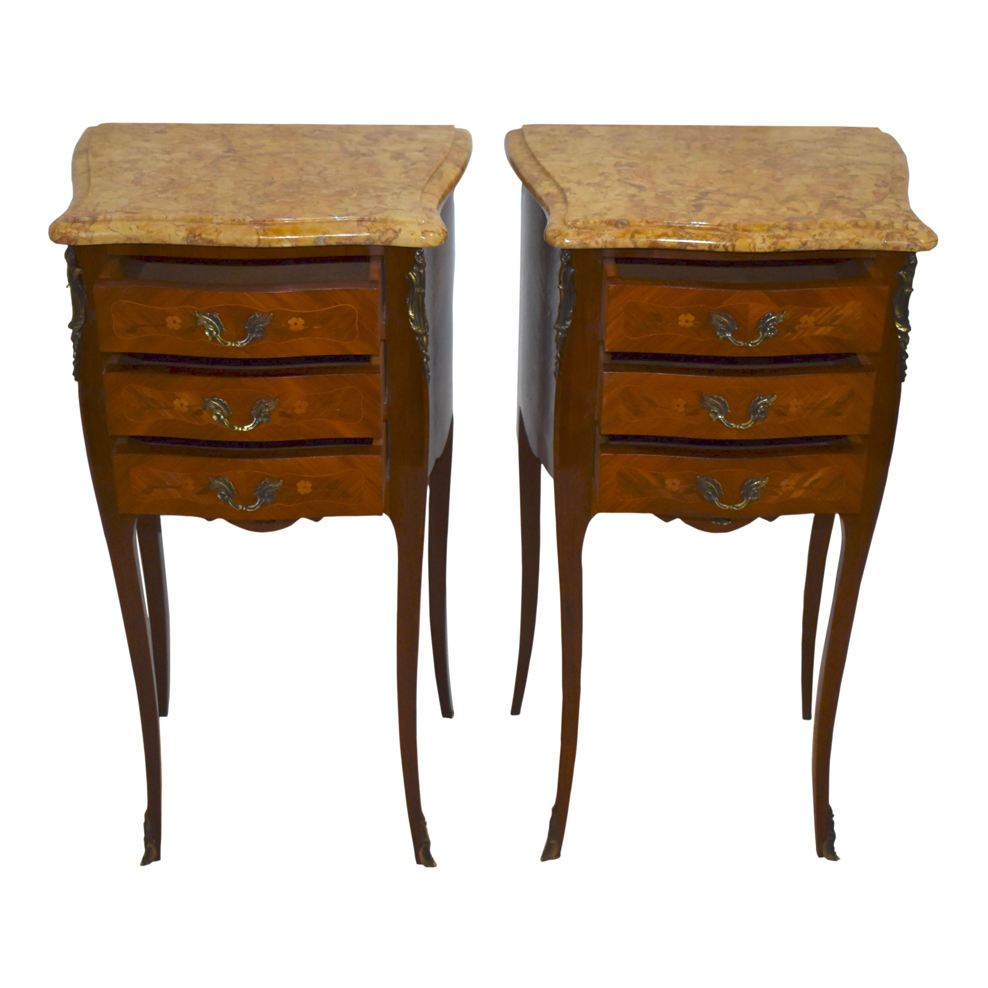 Petite and graceful, this set of two Louis XV nightstands crafted in the late-19th century pairs stunning marble tops over mahogany, bombe shaped bases raised on slender saber style legs that taper and terminate in decorative sabots. The marble