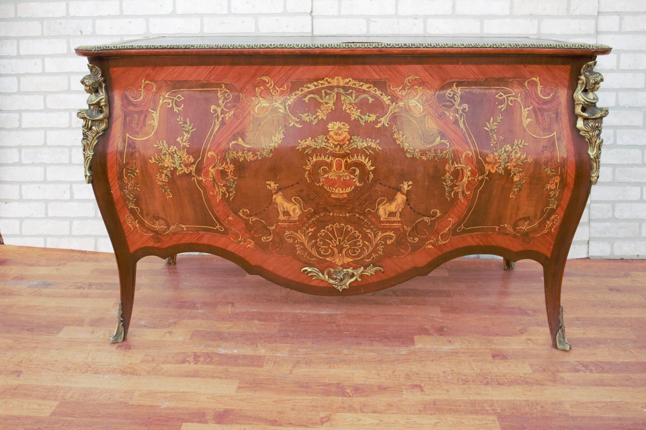 Antique French Louis XV Marquetry Style Mahogany Brass Ormolu Mounted Bombe Leather Top Desk

A unique French Louis XV style ornate ormolu gilt mounted figural desk. The desk has a bombe style look to it. Very different compared to the desks we