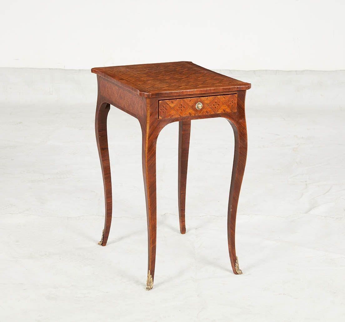 Table d'appoint en marqueterie de bois de roi Louis XV, le plateau est orné de fleurs à quatre pétales incrustées dans une bordure en damier, surmontant un seul tiroir et reposant sur de gracieux pieds cabriole se terminant par des sabots en laiton