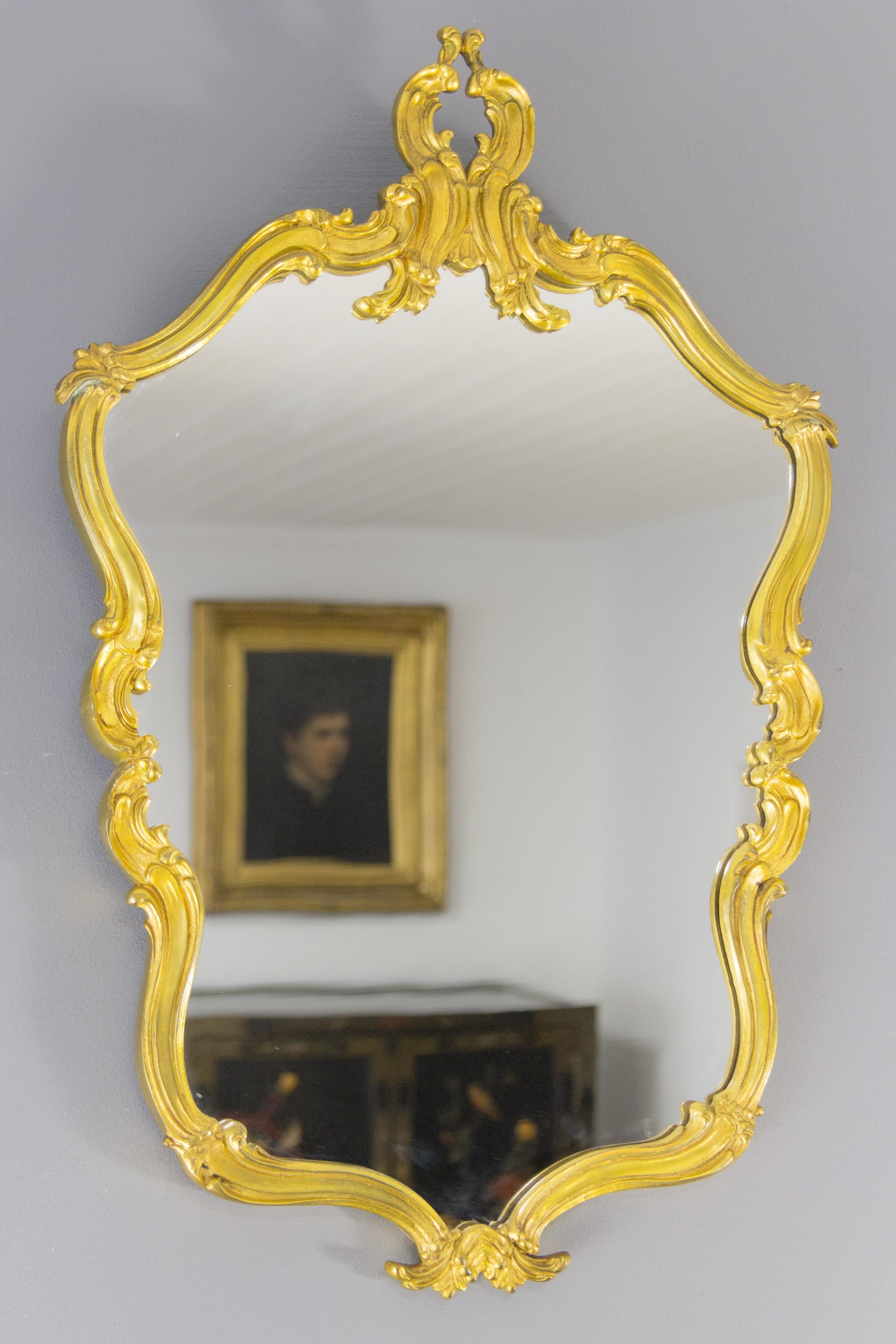 Elegant and beautiful, oval shaped French Rococo style or Louis XV style wall mirror in gilt bronze, decorated with leaf scrolls, circa 1950s.
Dimensions: Height 66 cm / 26 in; width: 43.5 cm / 17.12 in; depth: 2 cm / 0.78 in.