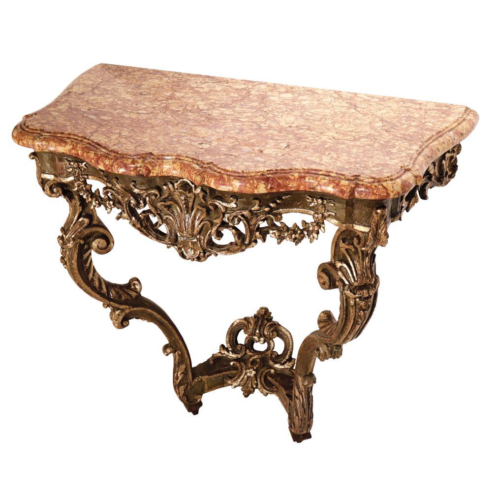 Console D’Époque Louis XV, a two-legged wall table, carved of oak, painted and parcel gilt edge decorations and “Rouge de Rance” marble-top. A shaped and polished serpentine top above a foliate and floral garland pierced frieze, raised on acanthine