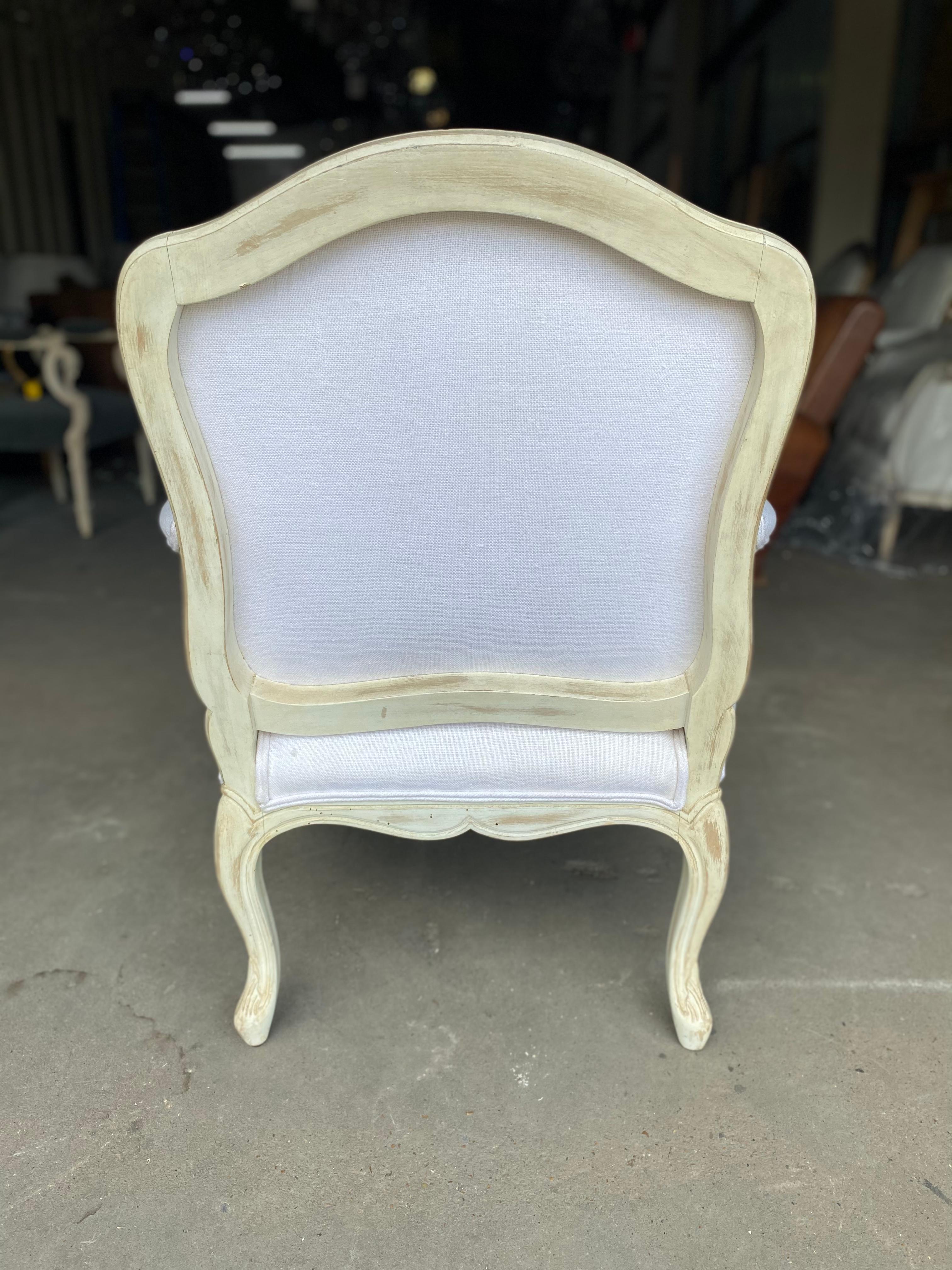 A beautiful newer pair of Louis XV style of chairs reupholstered in a white linen fabric. Perfect for any sitting room, at the foot of a bed, kitchen nook and more. The fabric has been professionally cleaned since we had these imported from Italy