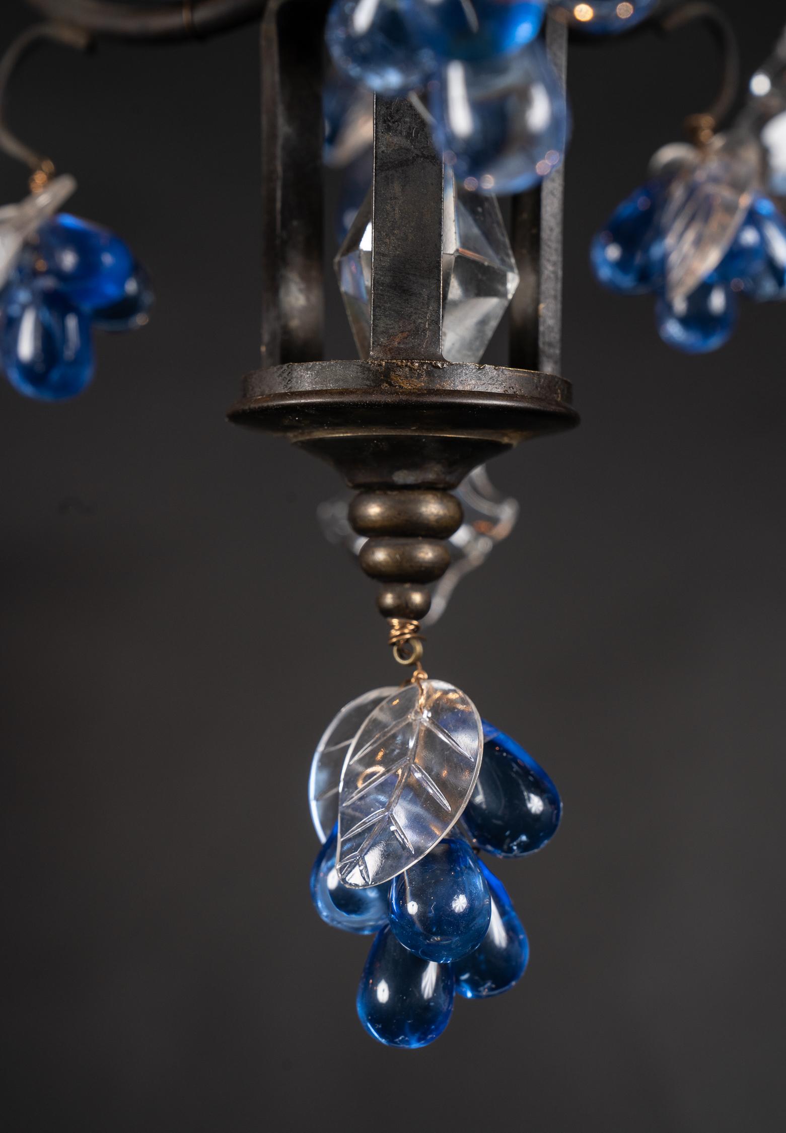 Ce lustre italien Louis XV est réalisé en bronze patiné dans un design classique de panier. Elle est ornée d'une couronne d'étoiles en cristal clair et de raisins en cristal bleu dont les feuilles sont gravées en clair. En suivant l'écoulement des