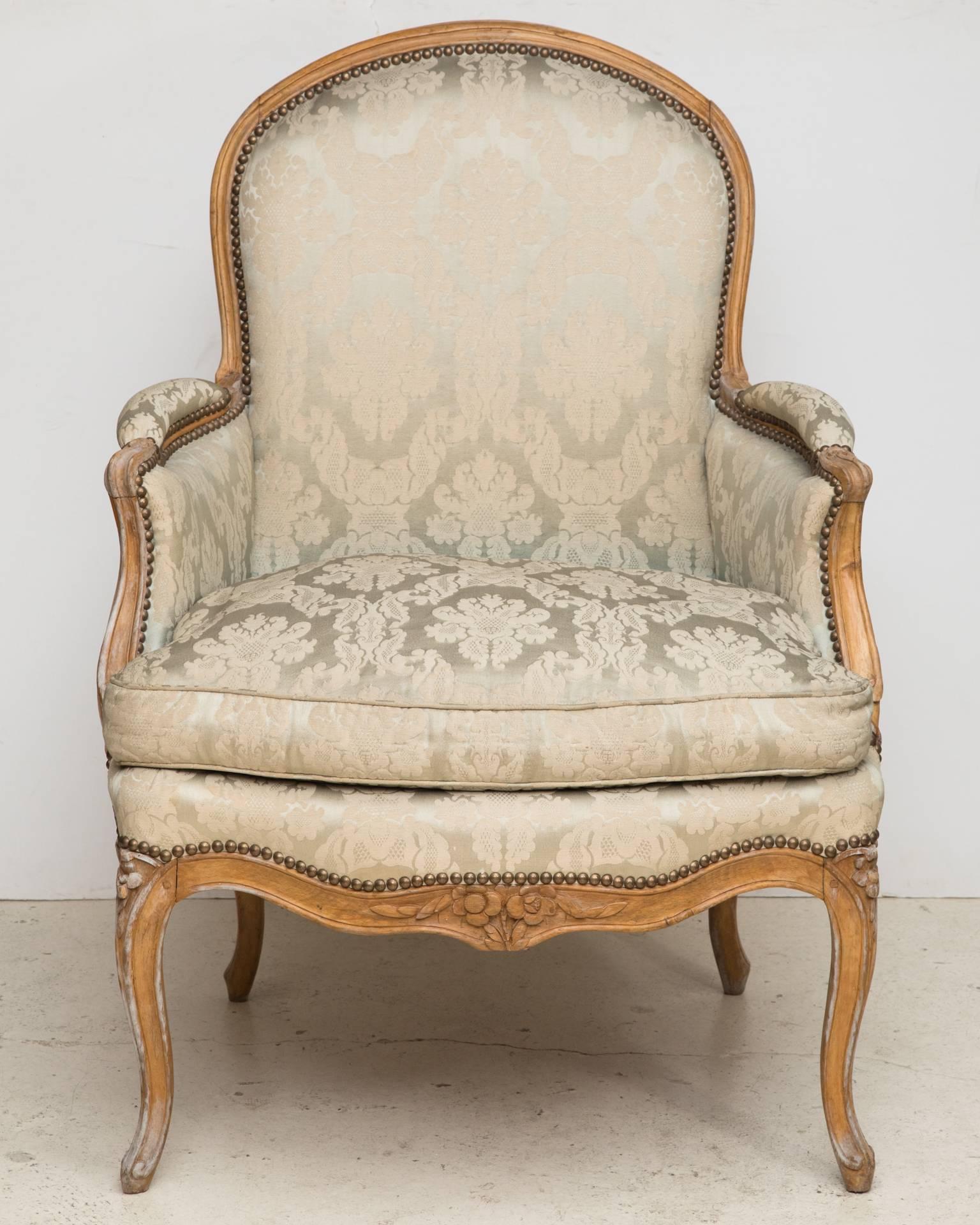 Beech frame curve backed armchair with Rococo carved cabriole legs and apron with flowers. Upholstered in beige silk damask with a loose seat cushion. Stamped by the maker, Noël Baudin, ébéniste reçu maître en 1763.
France, circa 1765.